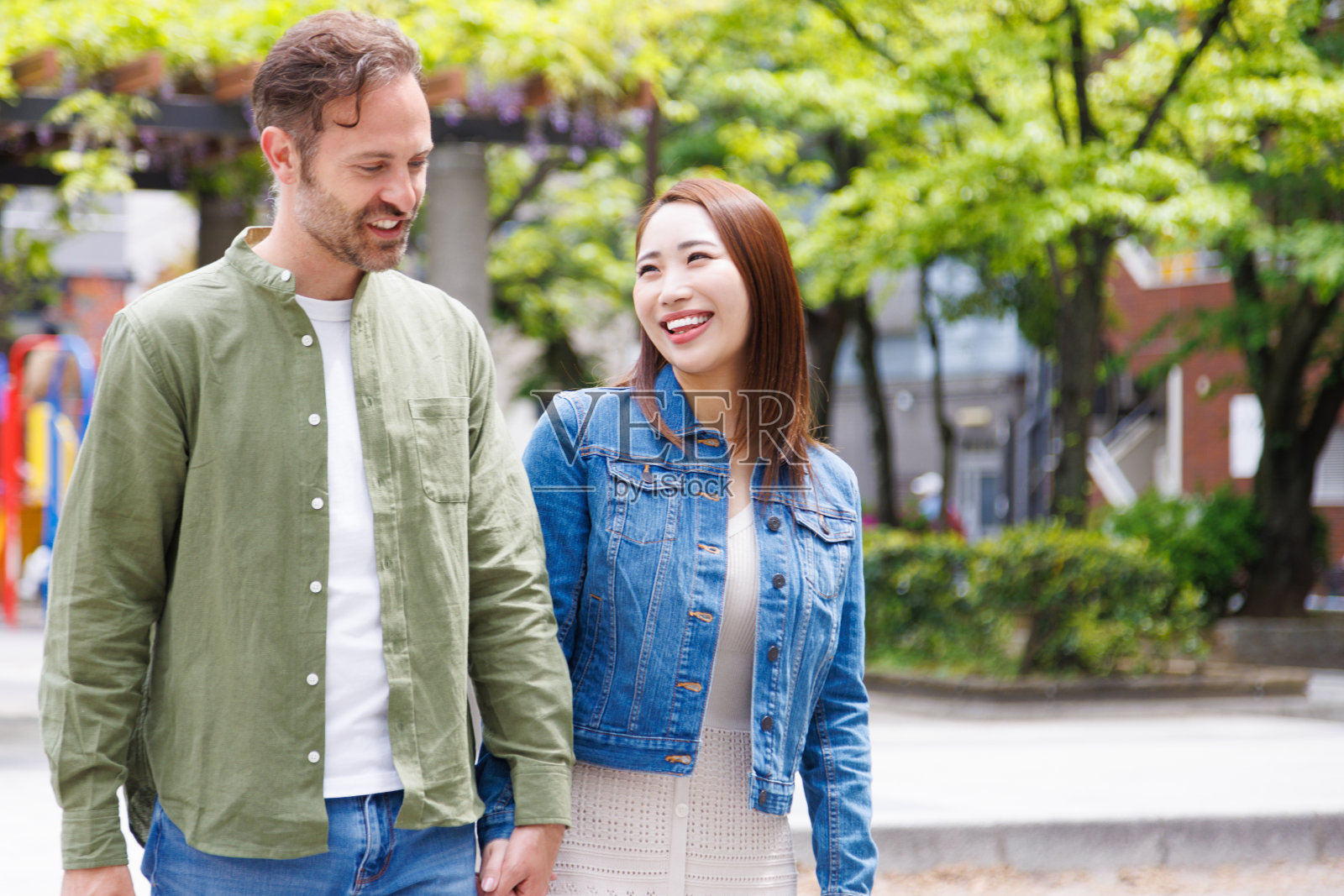 白人男人和亚洲女人手牵着手一起走照片摄影图片