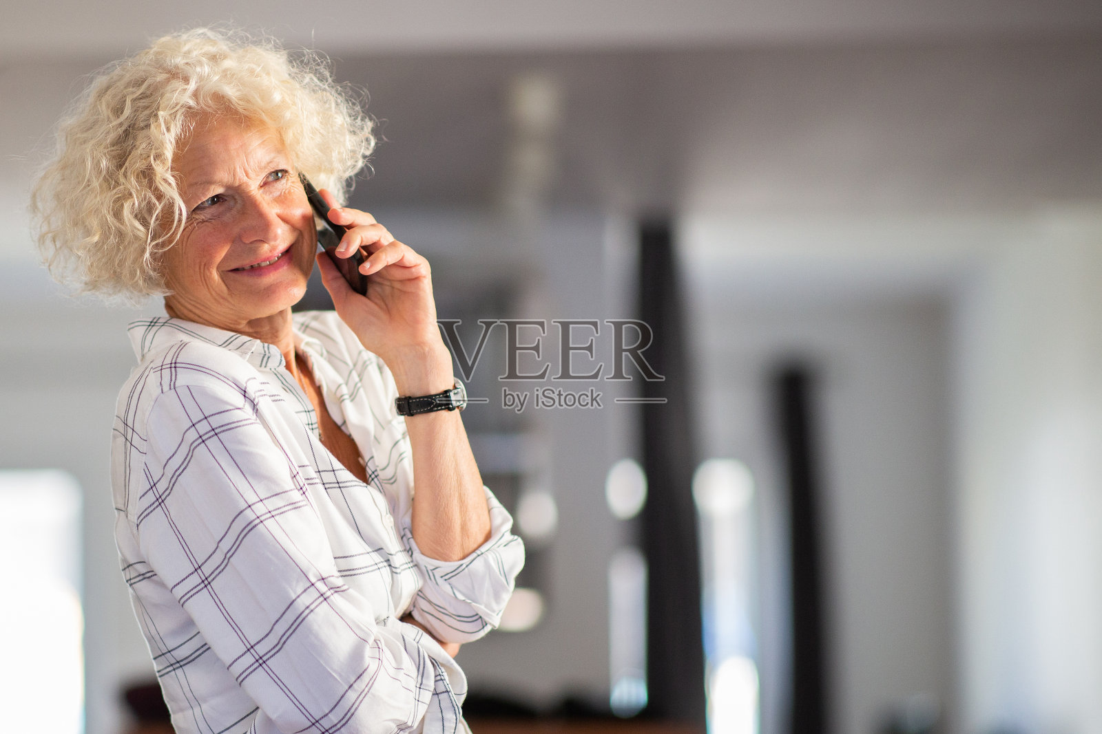 快乐的老妇人在家用手机聊天照片摄影图片
