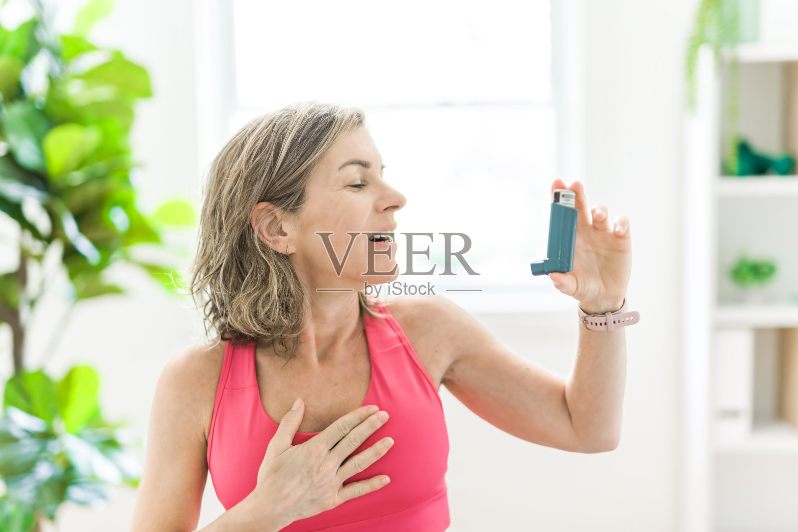 妇女在白色诊所使用哮喘吸入器照片摄影图片