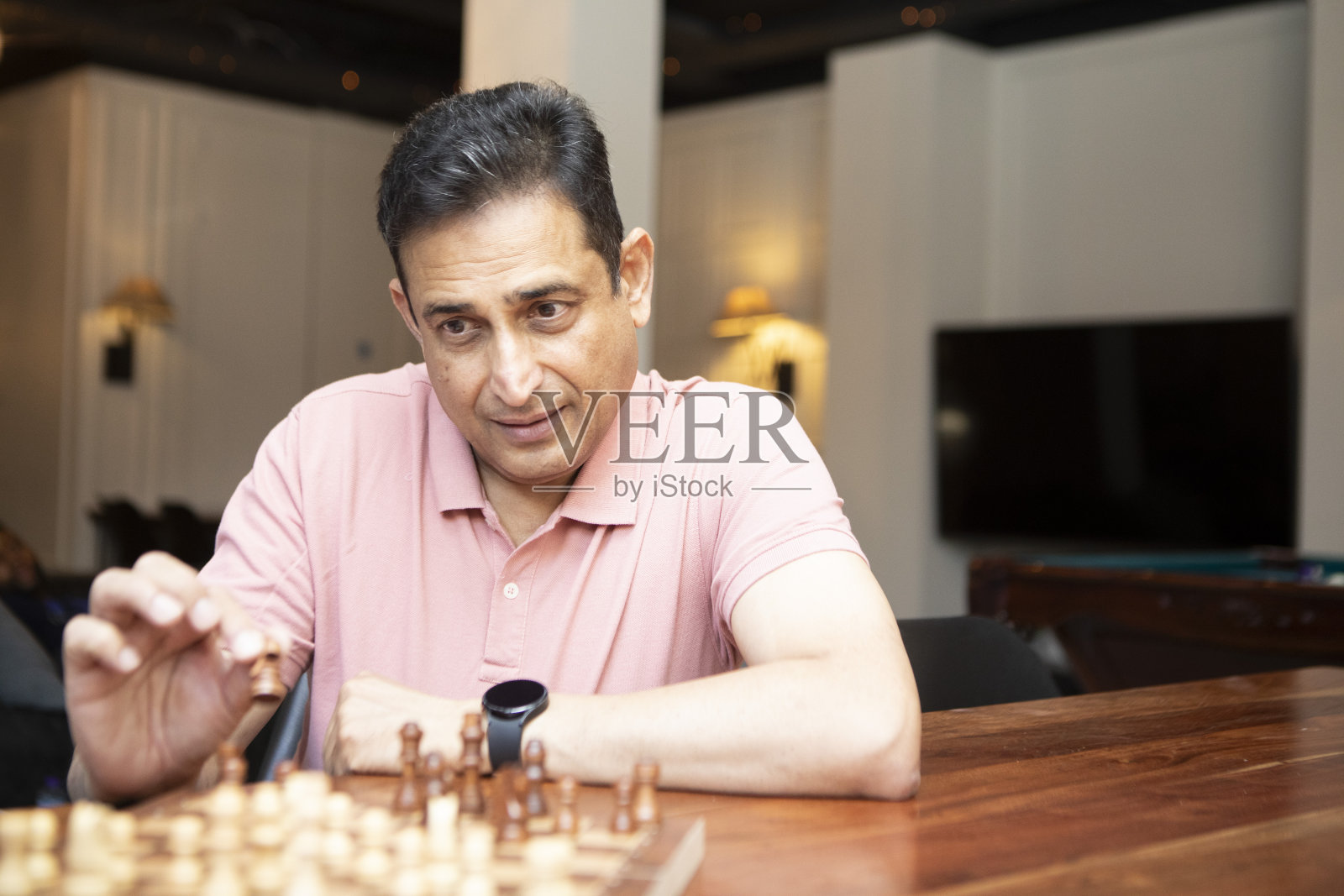 一个成熟的男人在现代建筑内部下棋照片摄影图片