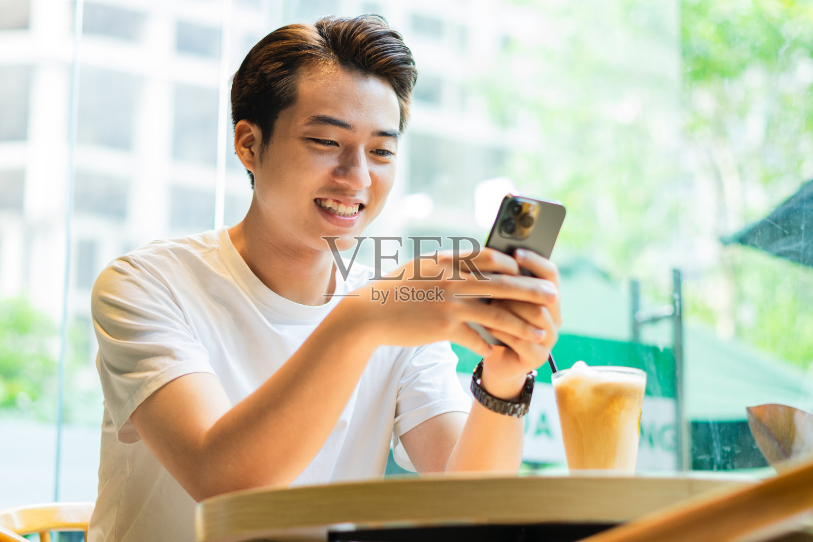 一个亚洲人坐在咖啡店里照片摄影图片