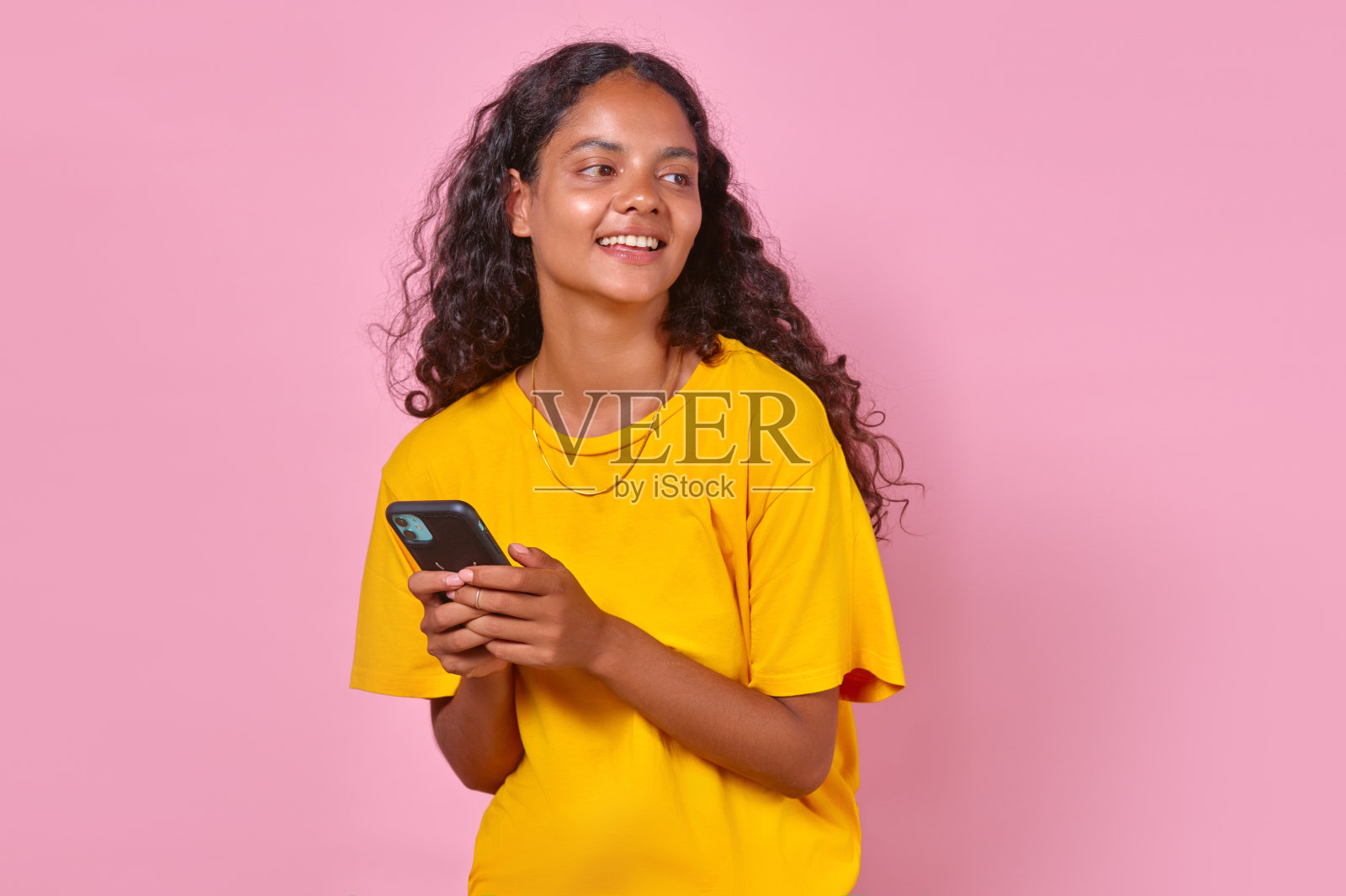 穿着便服的年轻笑着的印度少女用手机聊天照片摄影图片