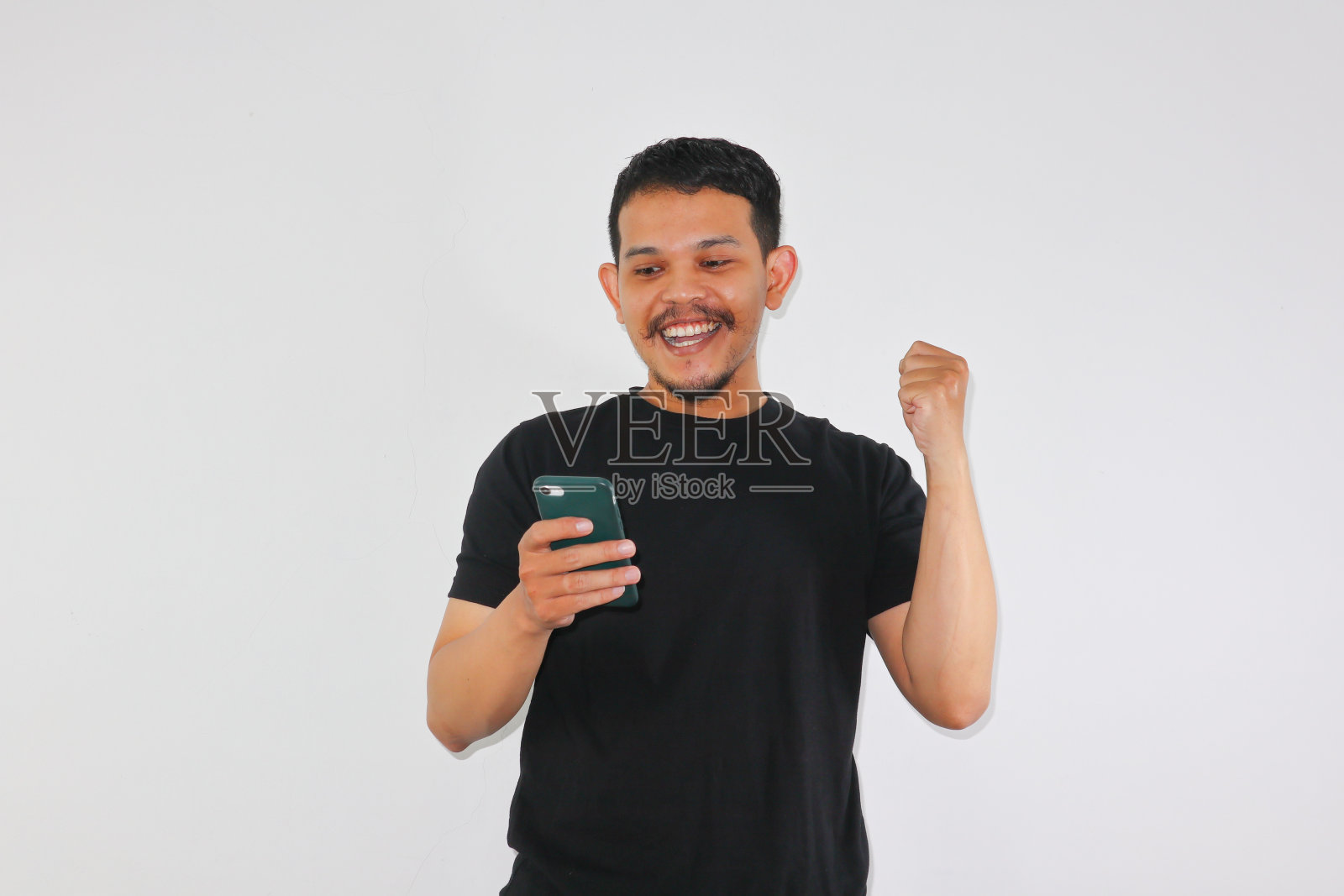 拿着手机的亚洲成年男子露出热情的表情照片摄影图片