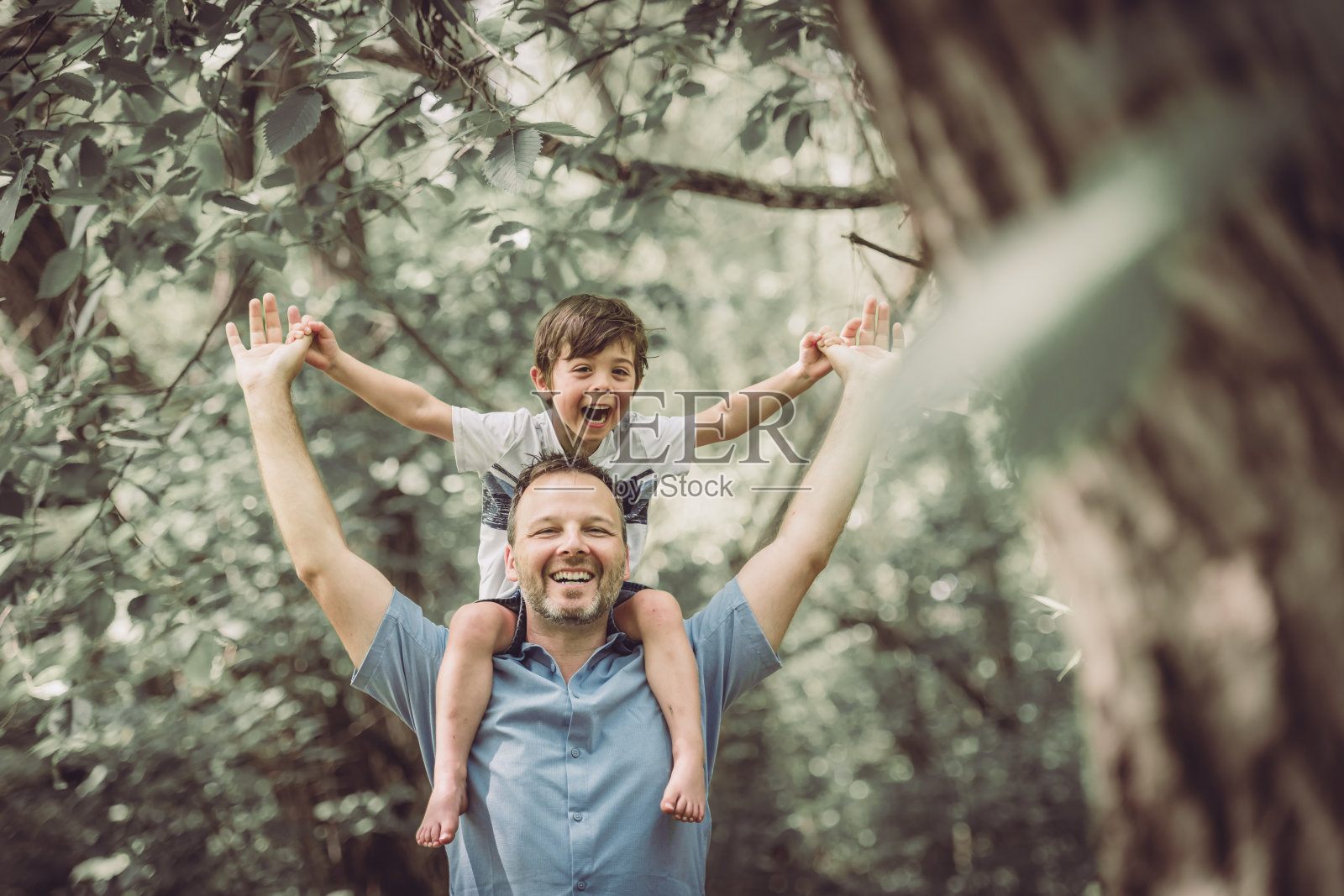 父亲带着他的小男孩在大自然中玩耍。照片摄影图片