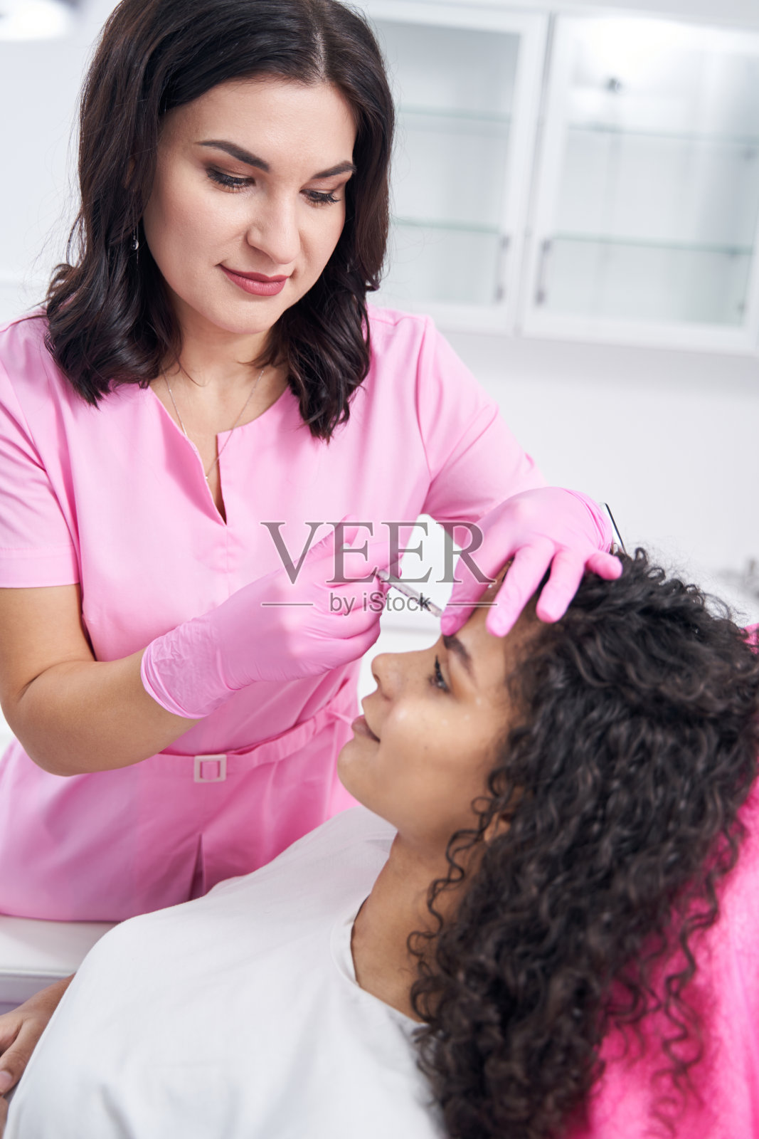 美容师注射特殊的工具在眉毛之间的折痕在脸上照片摄影图片