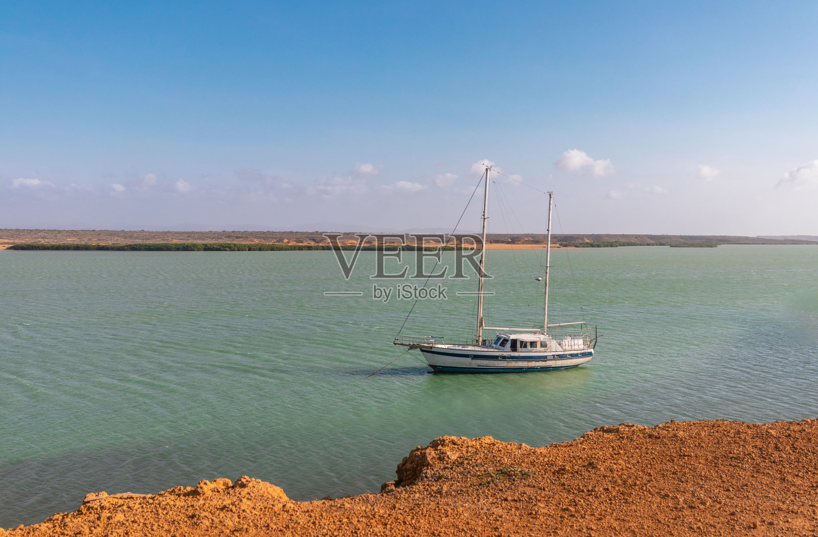 宁静的加勒比海湾:帆船停泊在橙色沙漠照片摄影图片