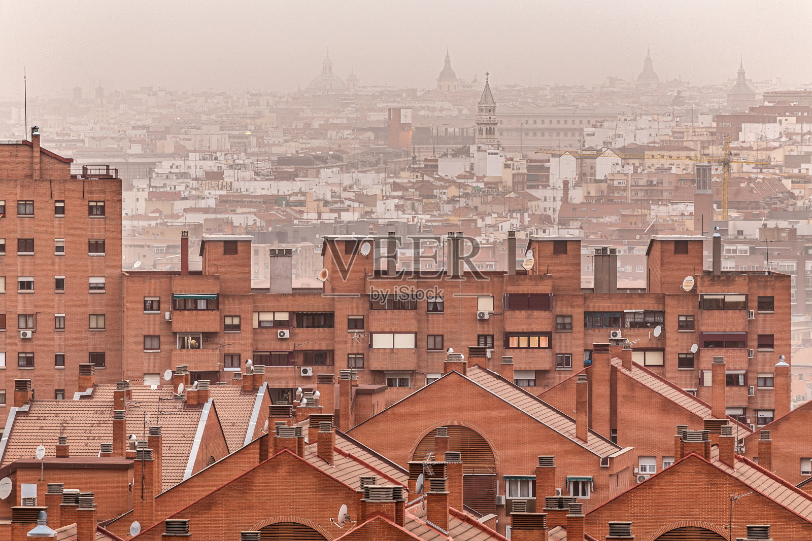 马德里的住宅楼由于撒哈拉沙漠的灰尘而笼罩在橙色的大气中。环境污染和呼吸困难照片摄影图片