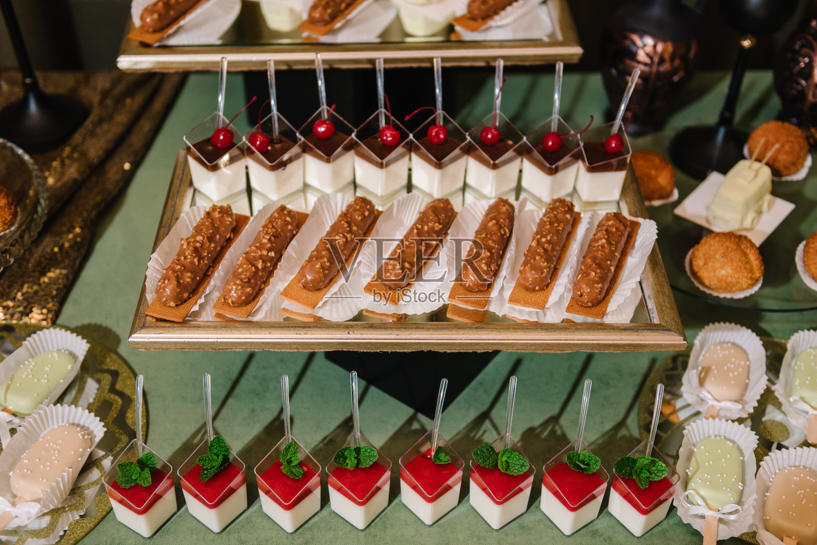 糖果棒和甜点庆祝生日,洗礼,婚礼派对。餐馆里摆满糖果、糖果和甜点的节日餐桌。金婚上的豪华糖果棒。前视图。特写镜头。照片摄影图片