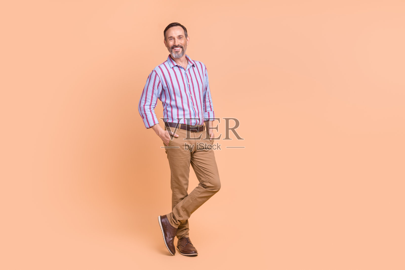 肖像友好的人与白色灰色的胡子穿着彩色衬衫手臂在办公室的口袋里,孤立在柔和的颜色背景照片摄影图片