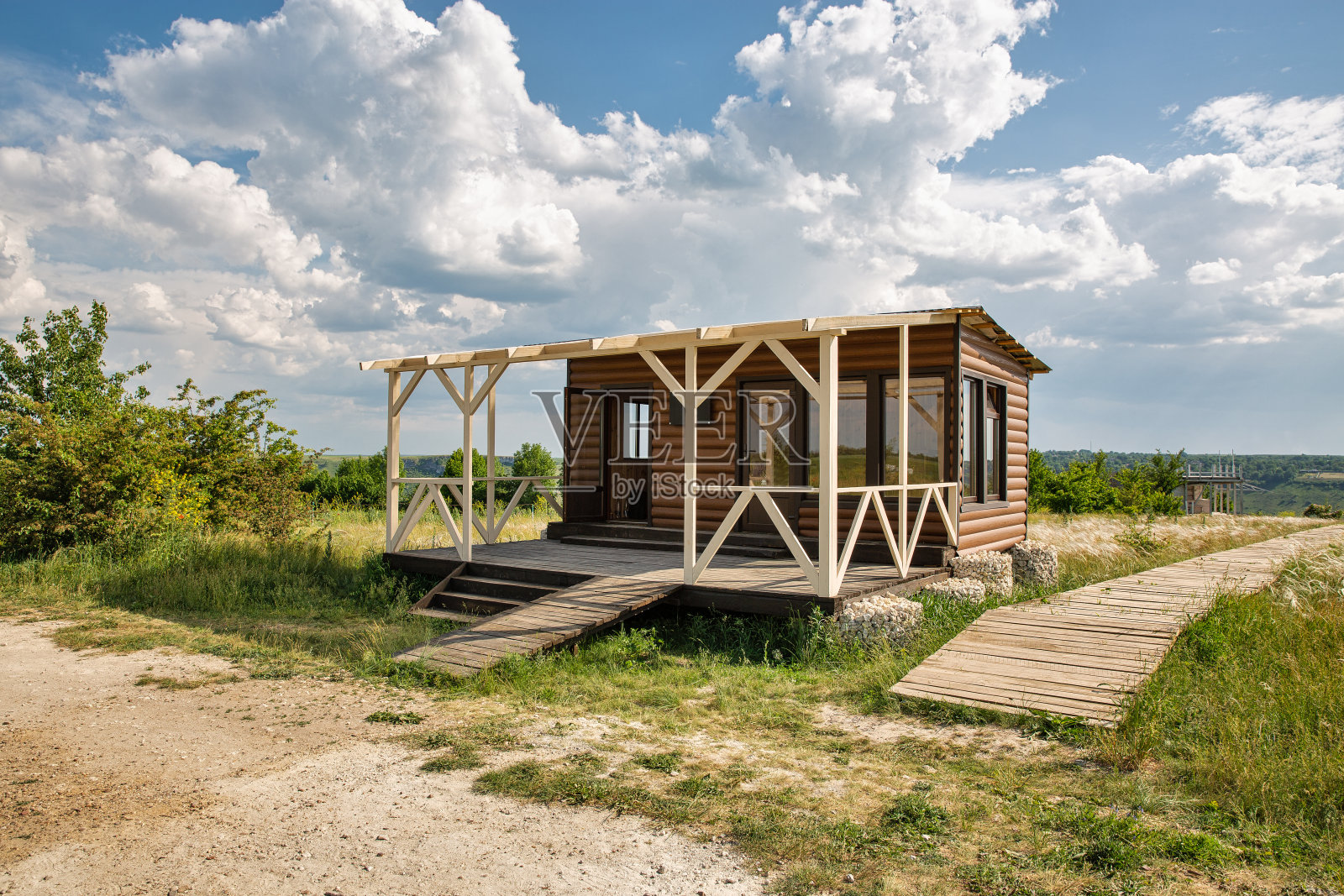 小现代的房子在一个干净的田野与木制木板路照片摄影图片