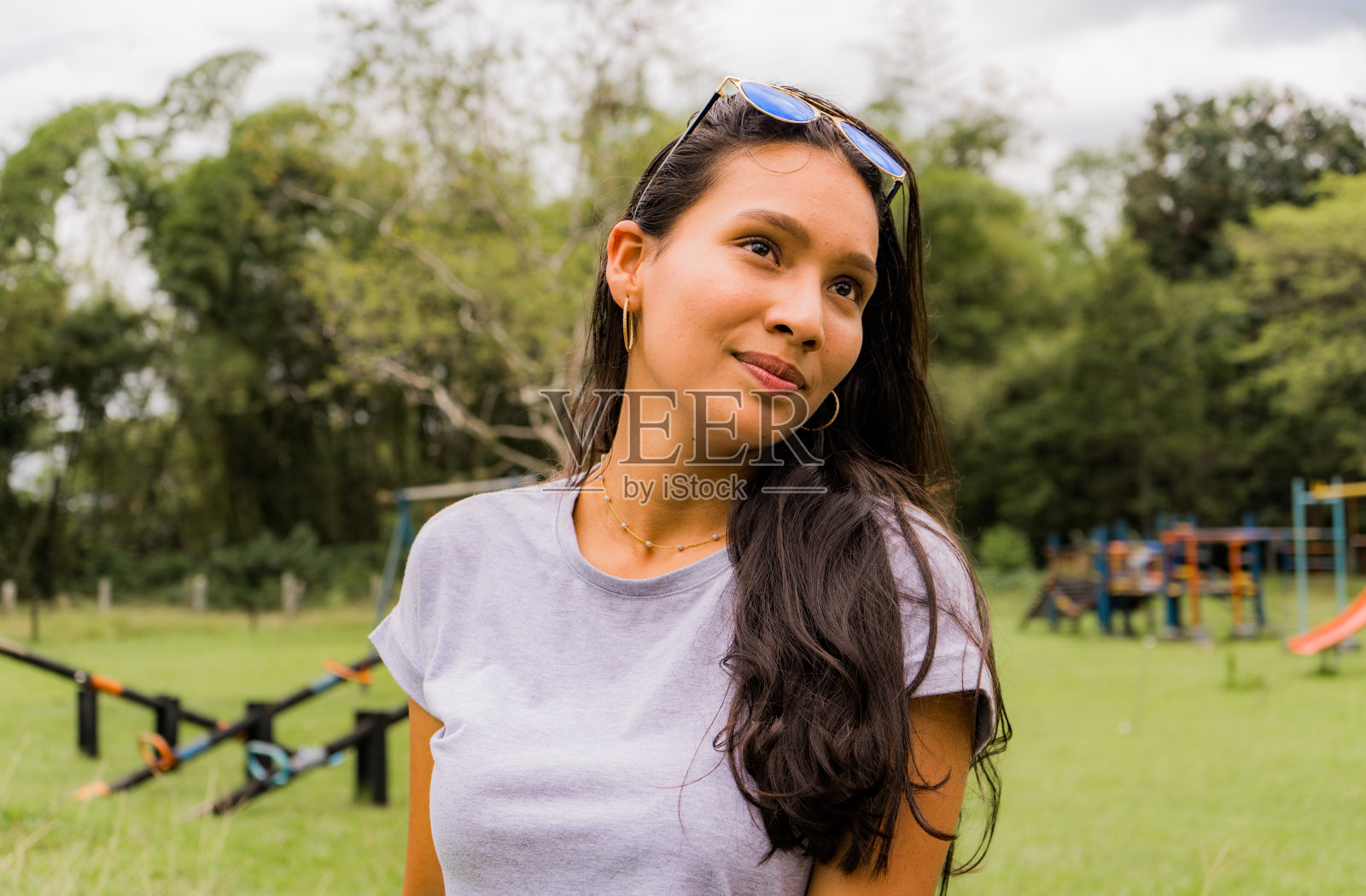 一个棕色头发的年轻白人女学生的特写肖像,在公园的树林里散步,看起来很随意照片摄影图片