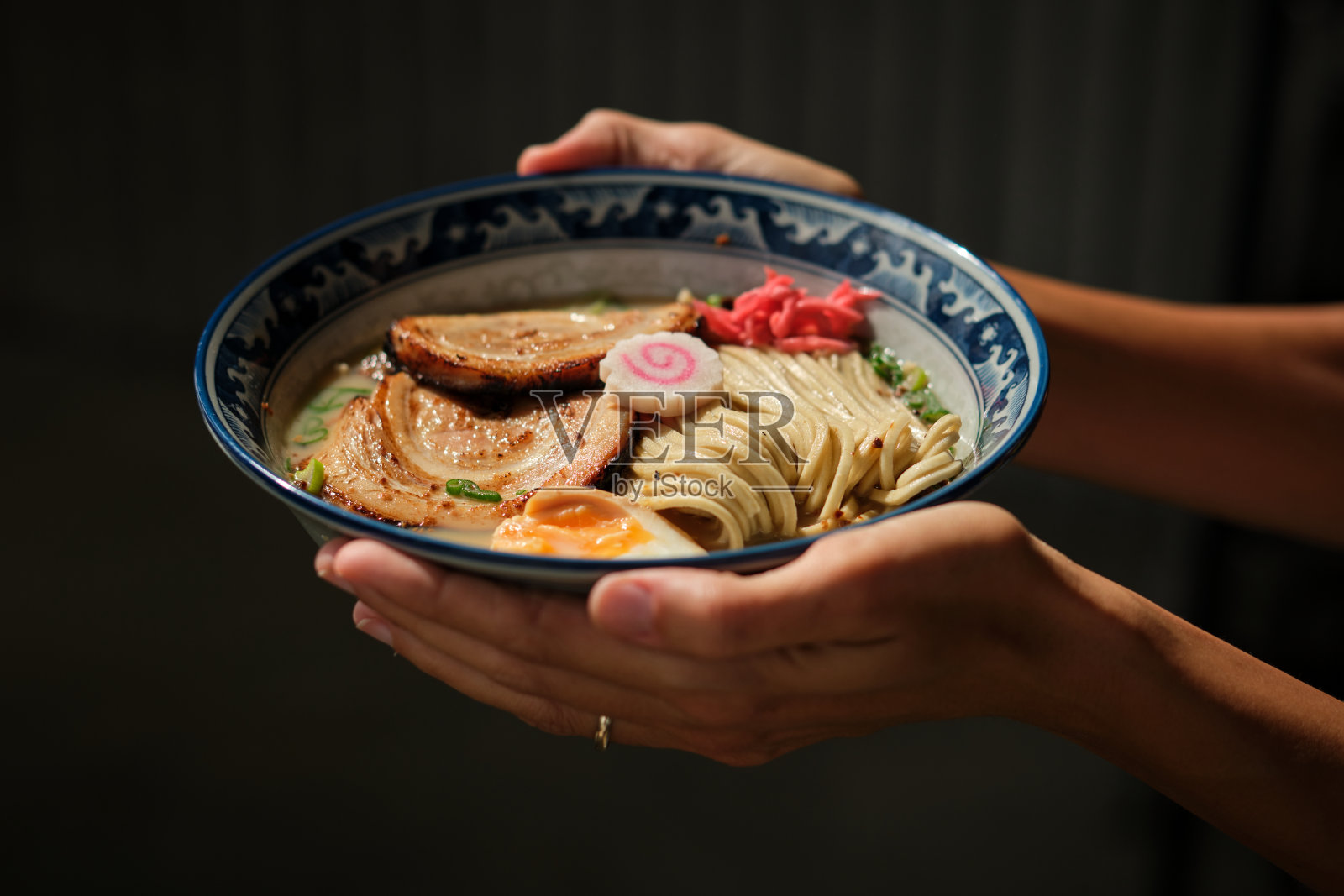 农妇在阳光下展示一碗拉面照片摄影图片