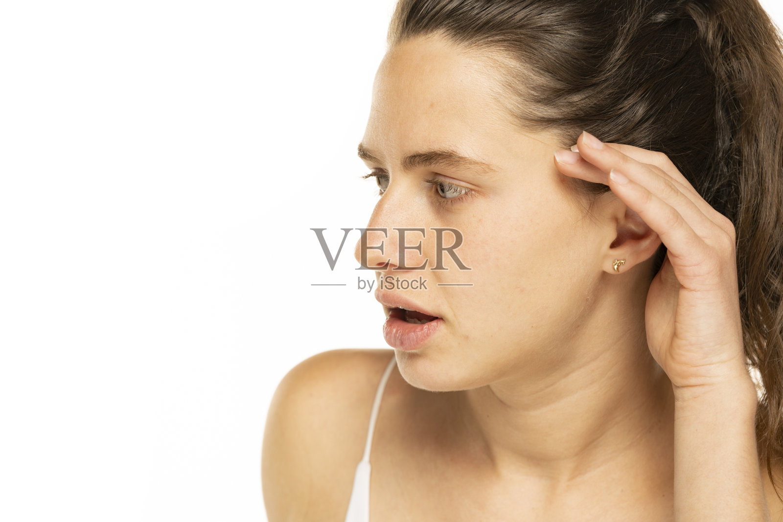 年轻女子用手捂住耳朵,背景是白色的照片摄影图片