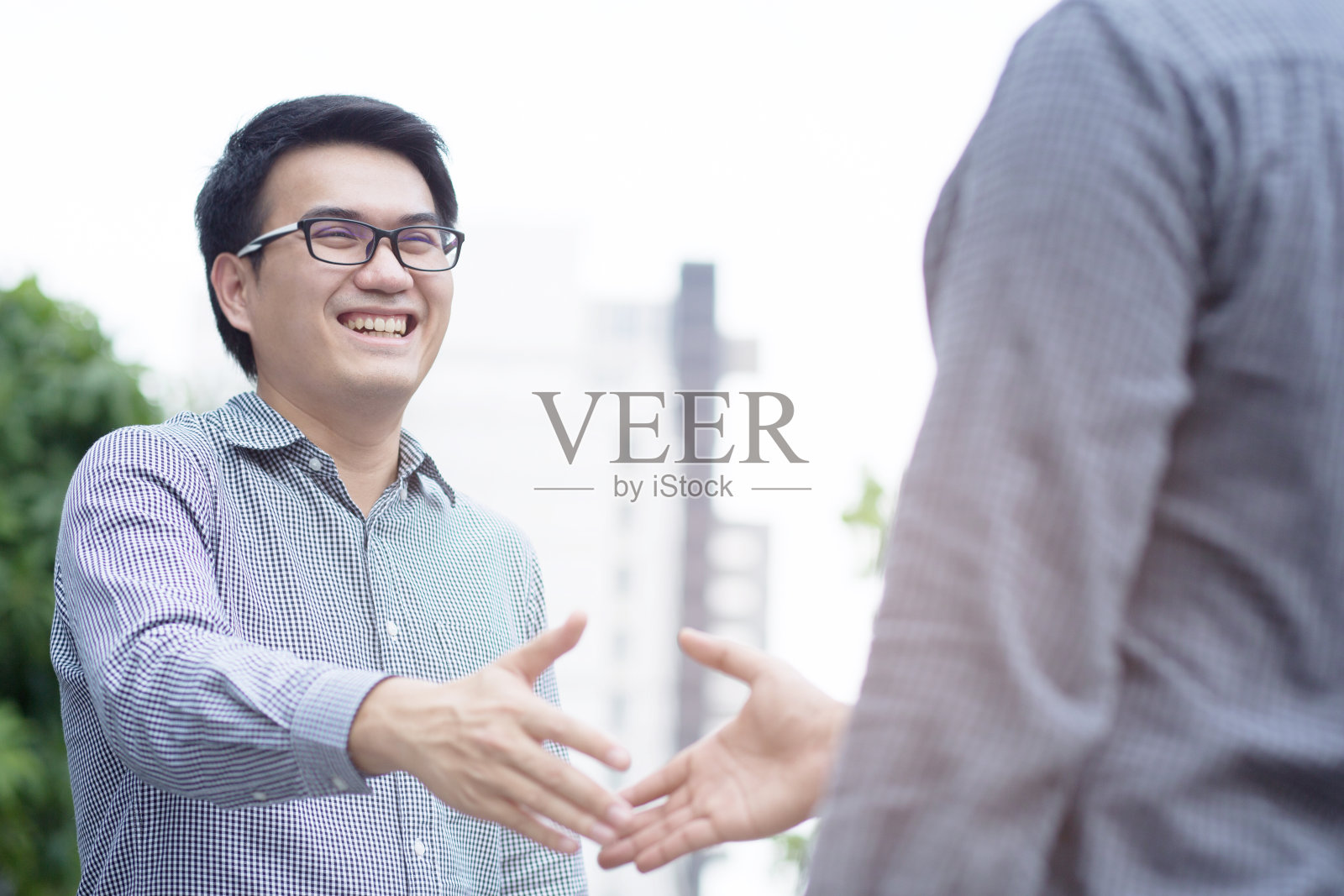 年轻的商务人士握手问候。照片摄影图片