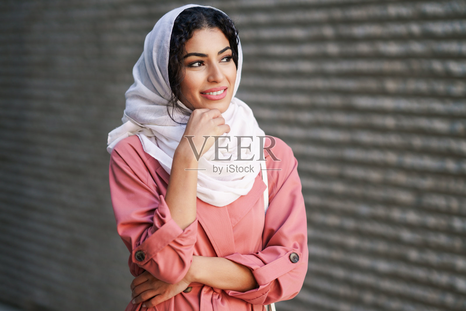 戴着头巾的年轻阿拉伯妇女走在市中心。照片摄影图片