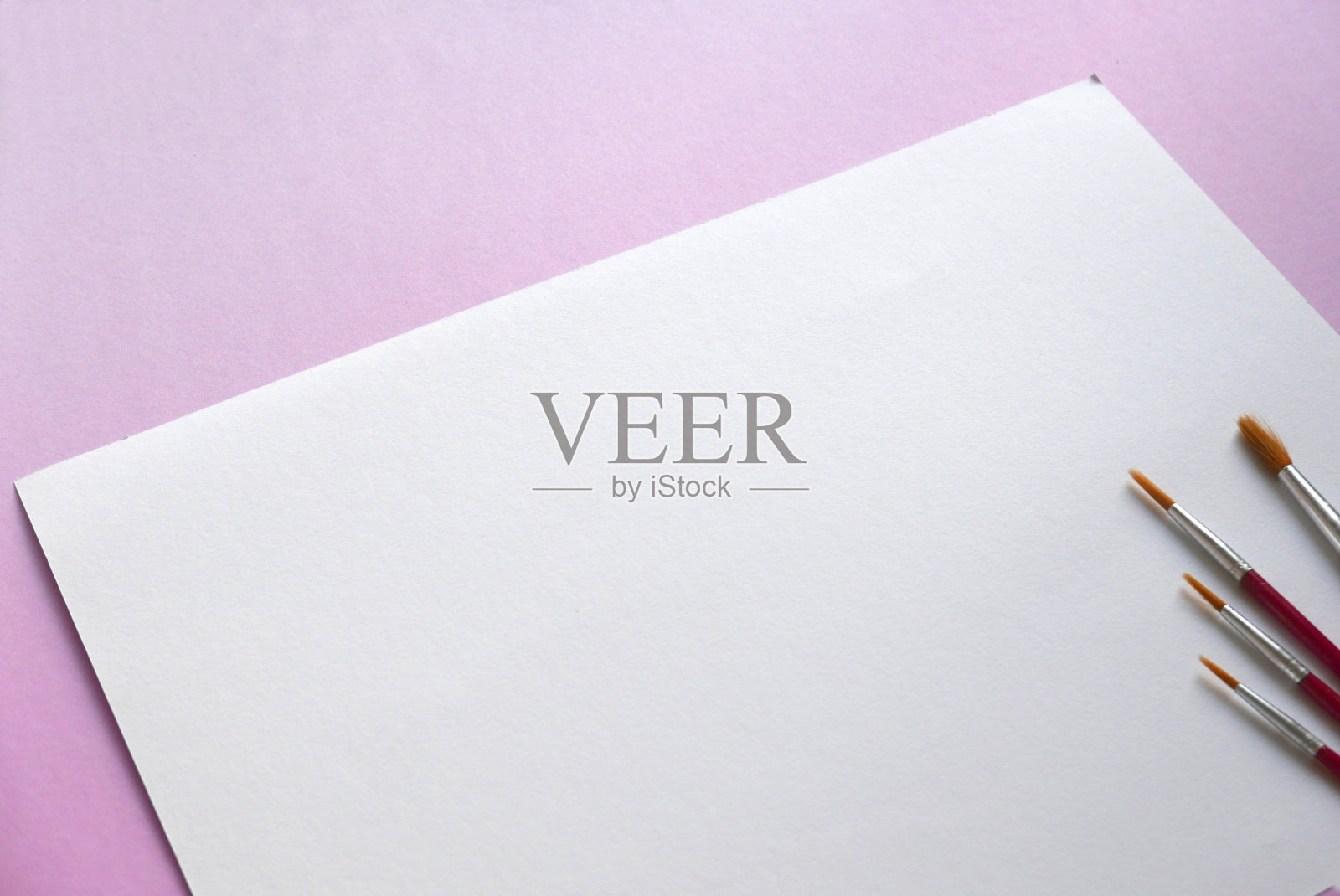 水彩笔在白纸的背景上,铺在粉红色的背景上。复制粘贴文本,标志等。照片摄影图片