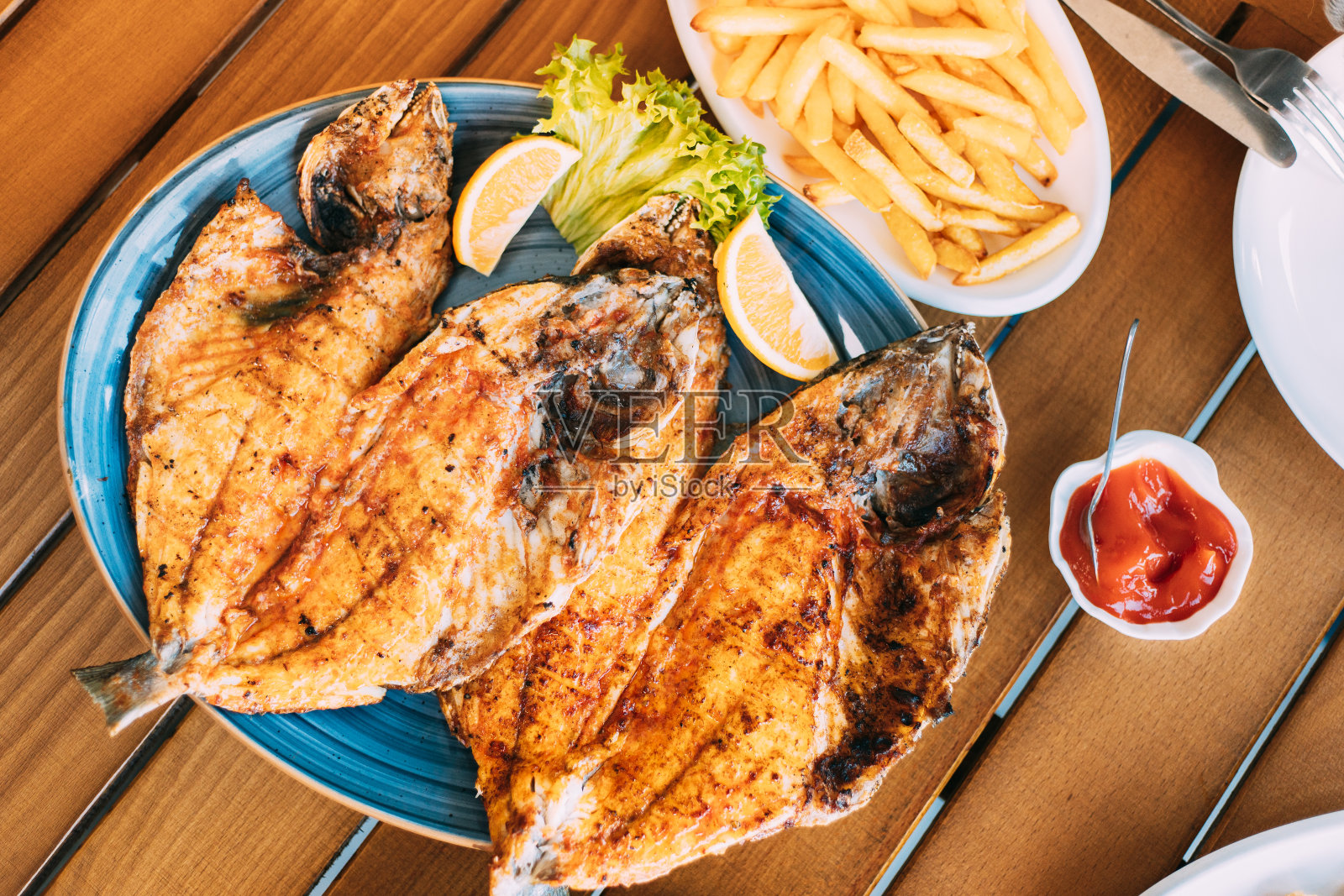 配有橙子和炸薯条的鲷鱼盘照片摄影图片