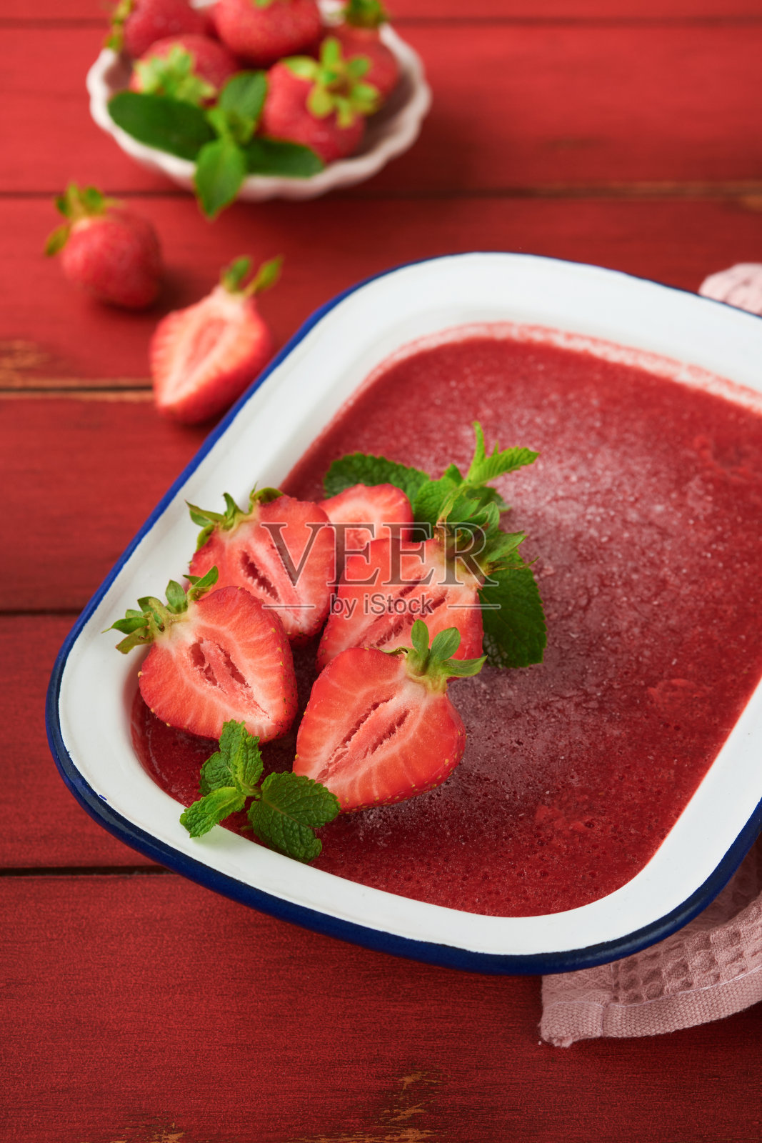 草莓格兰尼塔或新鲜的浆果冰沙在白色质朴的碗在旧木桌背景。草莓和薄荷冰淇淋。夏天治疗。前视图。照片摄影图片