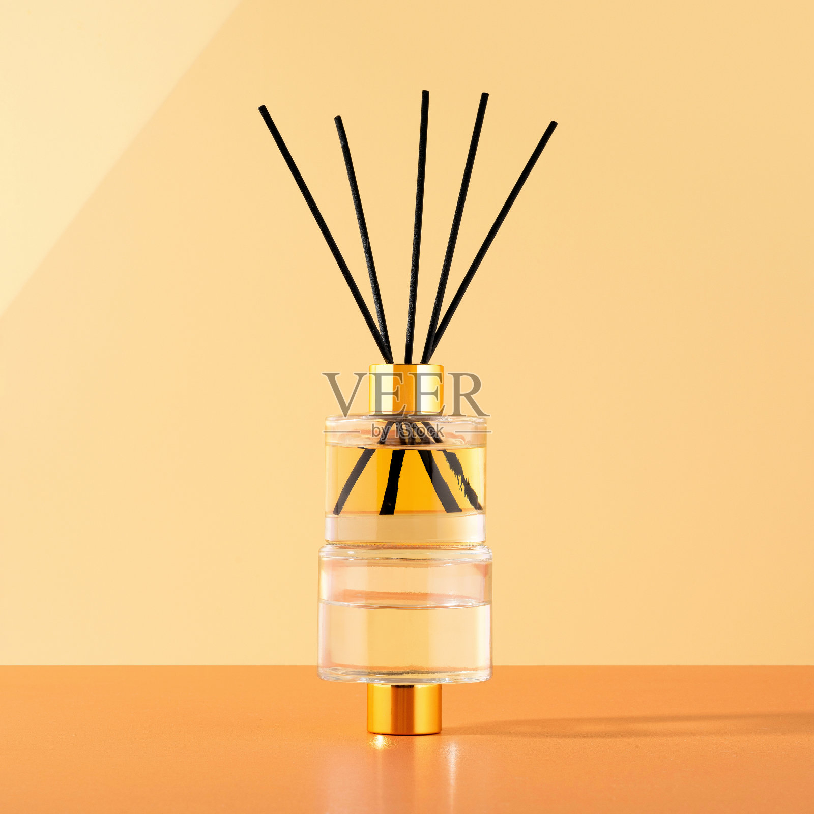 一个家的概念是舒适、装饰和香薰。在米色的背景上散发着精油的香味。两个玻璃扩散瓶在阳光下的创意时尚形象照片摄影图片