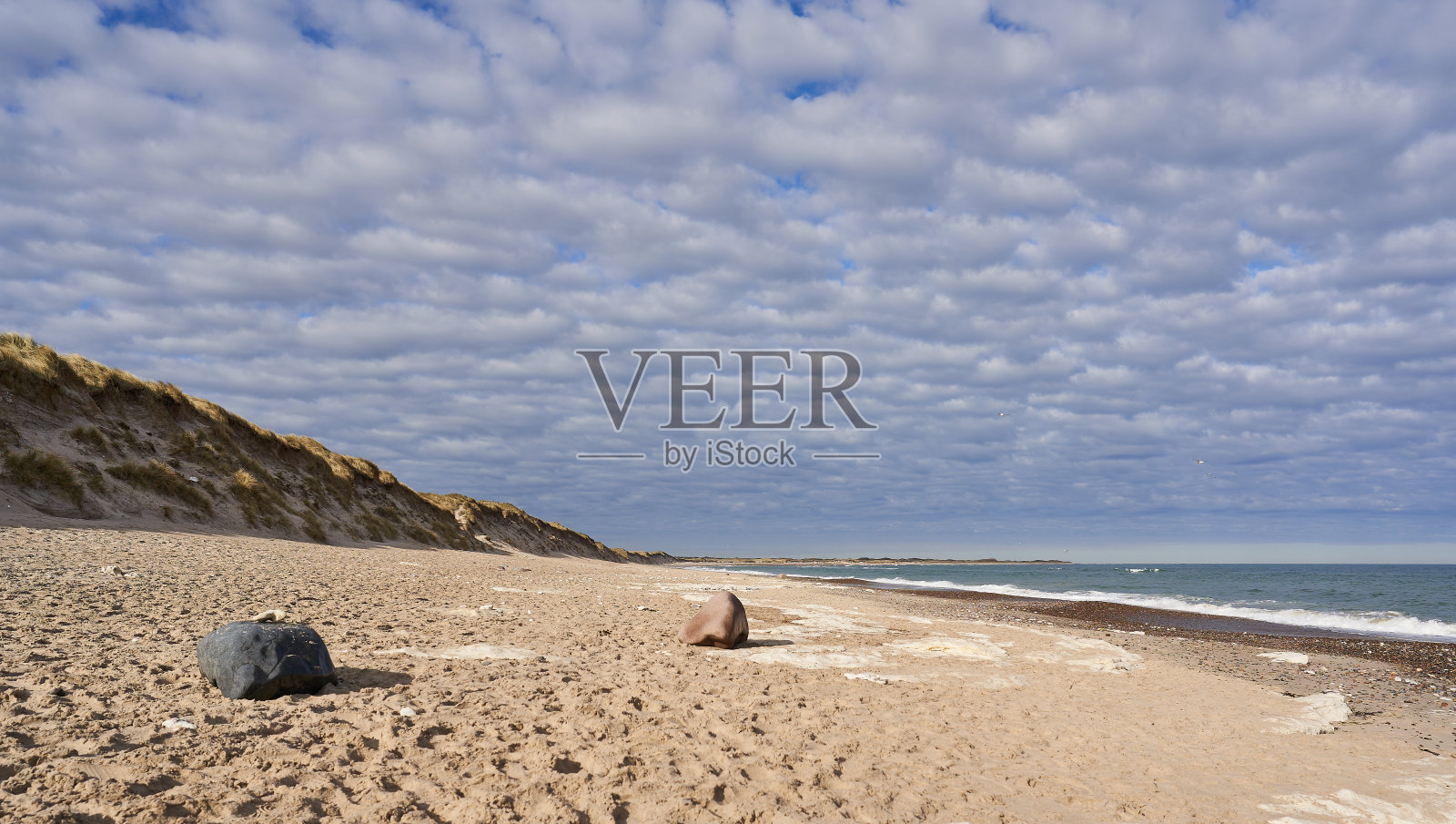 在多云的天空下,沙滩和大海的风景照片摄影图片