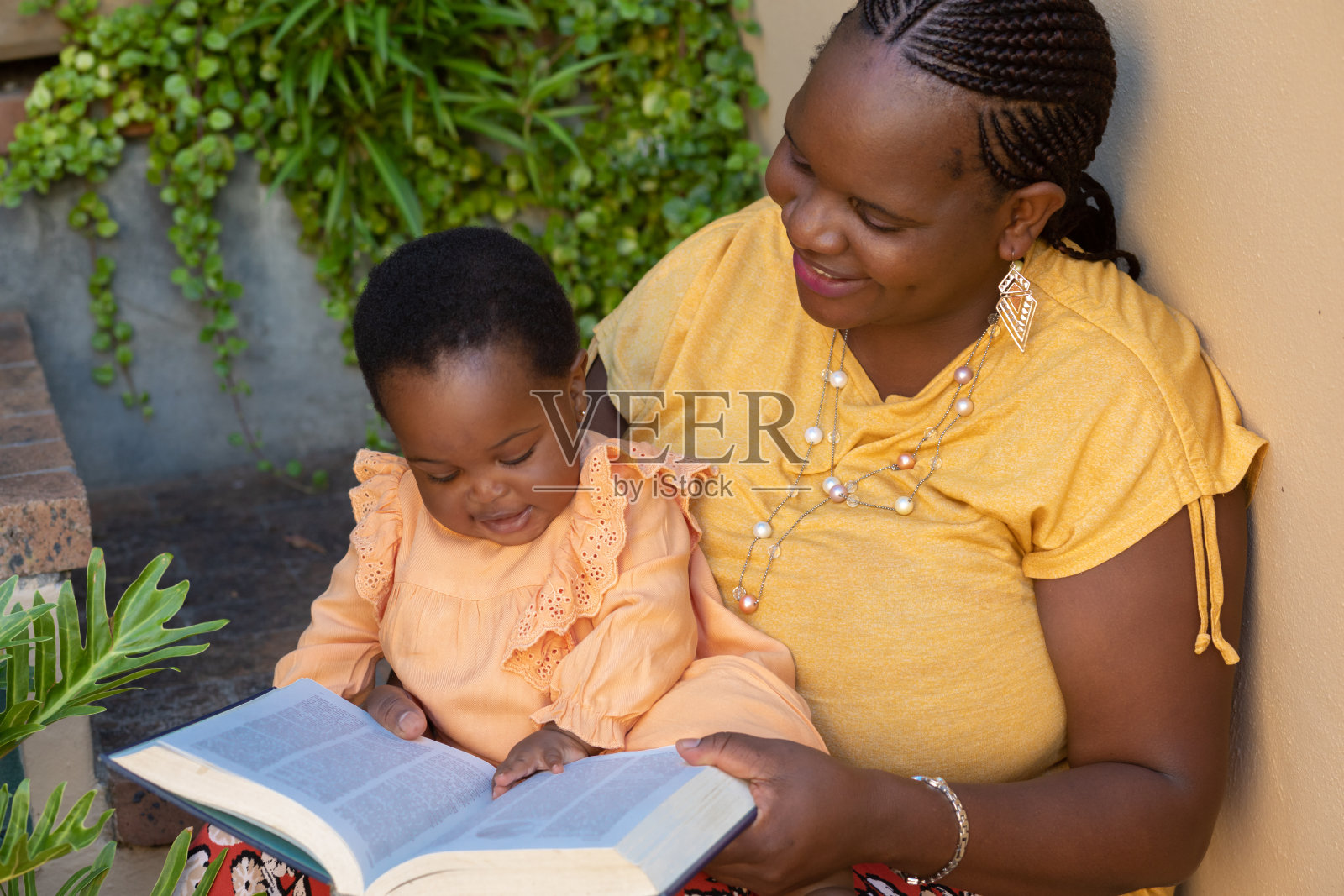 一个年轻的黑人母亲给她的小女儿读书的画像照片摄影图片