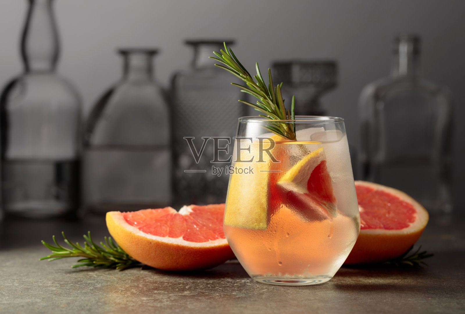 加冰、迷迭香和葡萄柚的鸡尾酒金汤力水。照片摄影图片