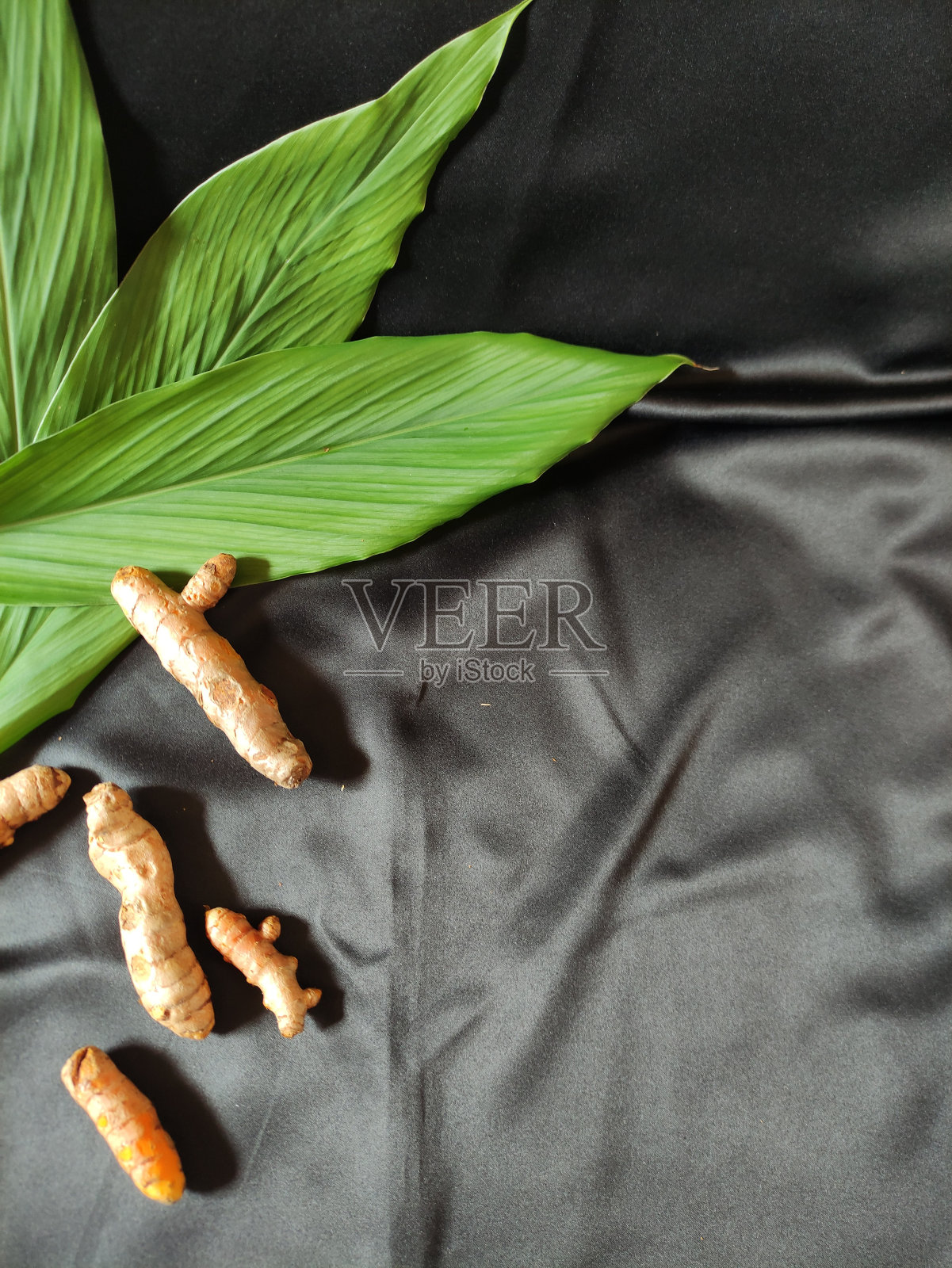 新鲜的姜黄和一些绿叶照片摄影图片