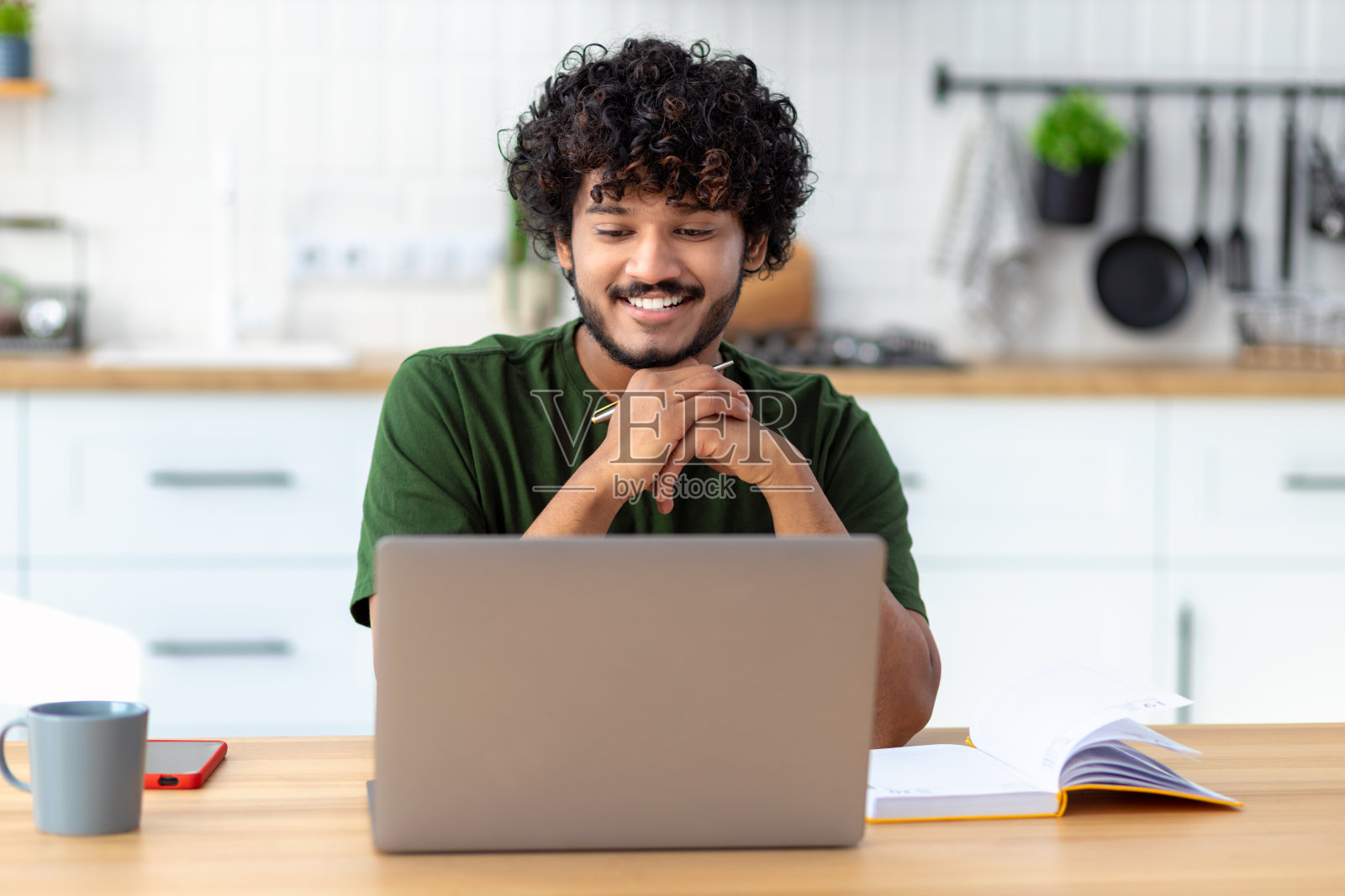 亚洲自由职业者使用笔记本电脑进行远程工作或观看在线培训,坐在家里的桌子旁参加网络研讨会照片摄影图片