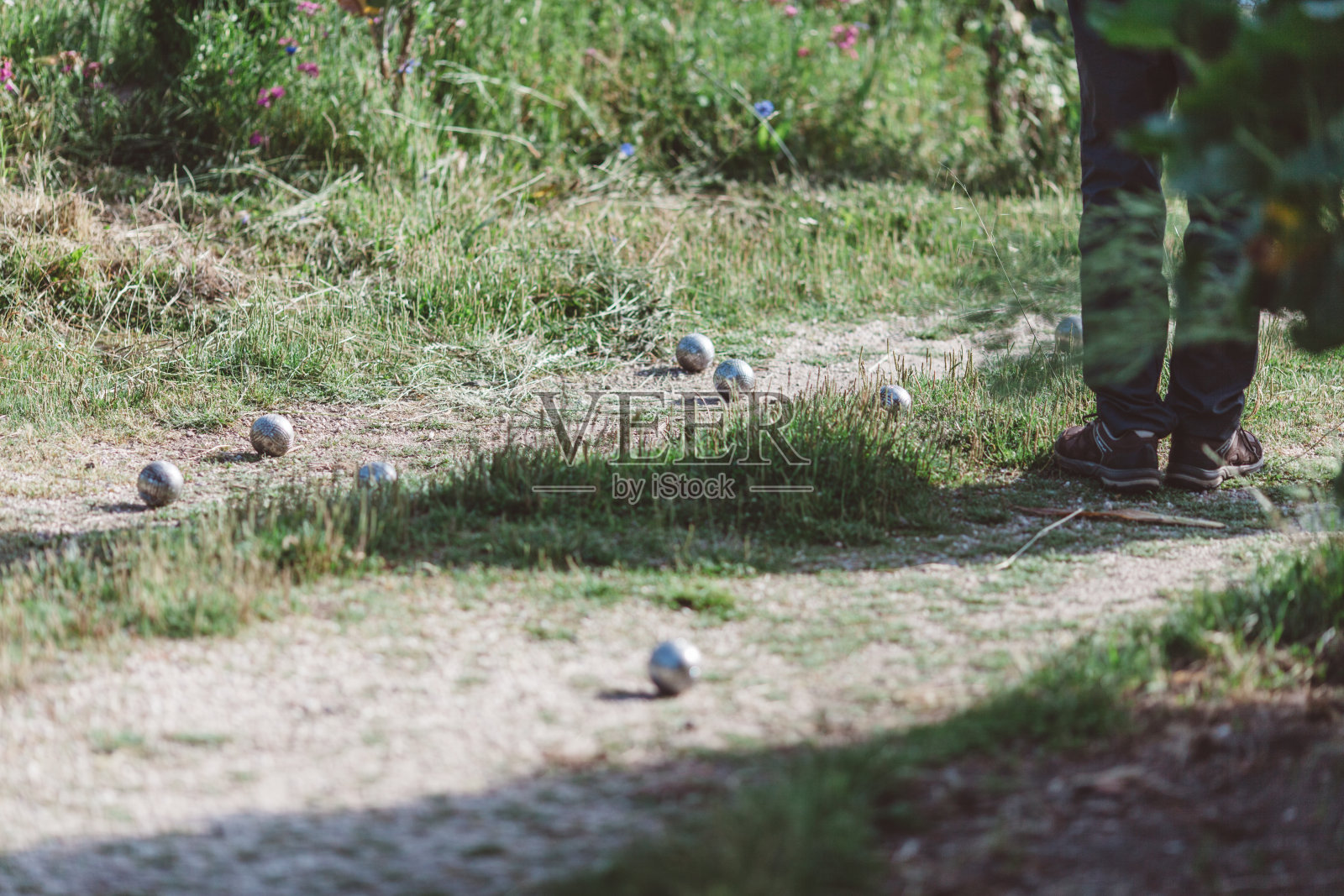 草地上站球的人的低段照片摄影图片
