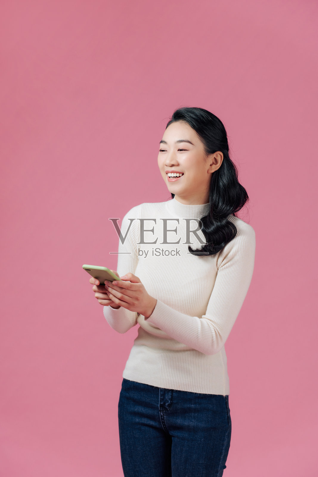 漂亮高兴的女孩的肖像打字短信给她的朋友照片摄影图片