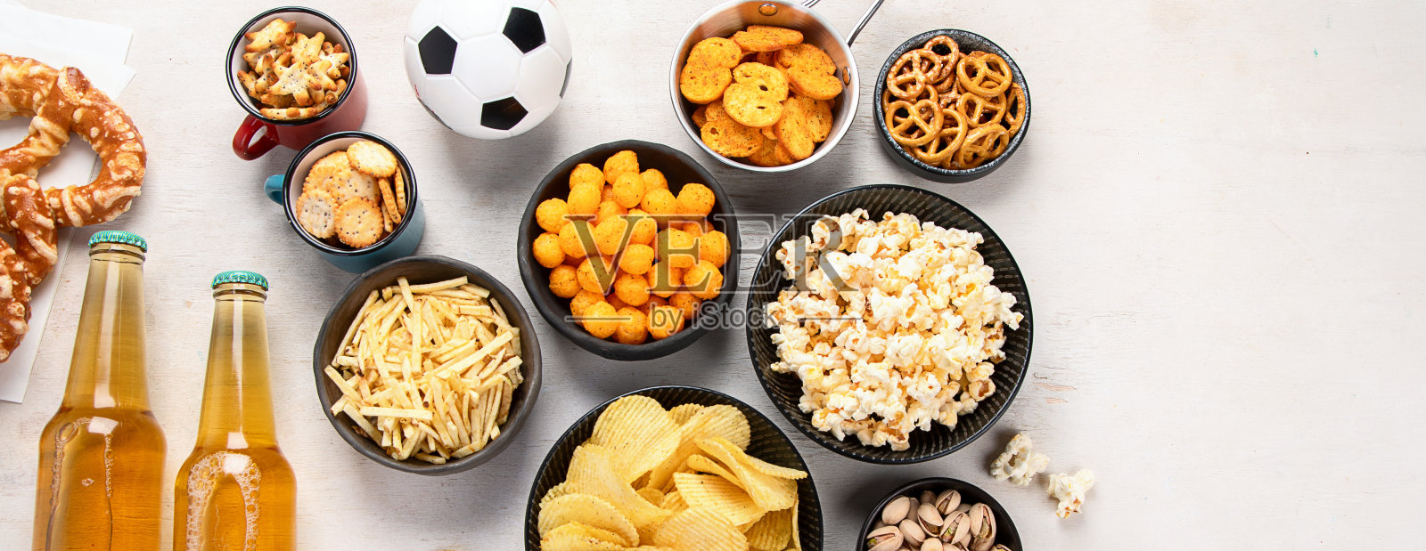 桌子上有啤酒瓶、零食和球。照片摄影图片