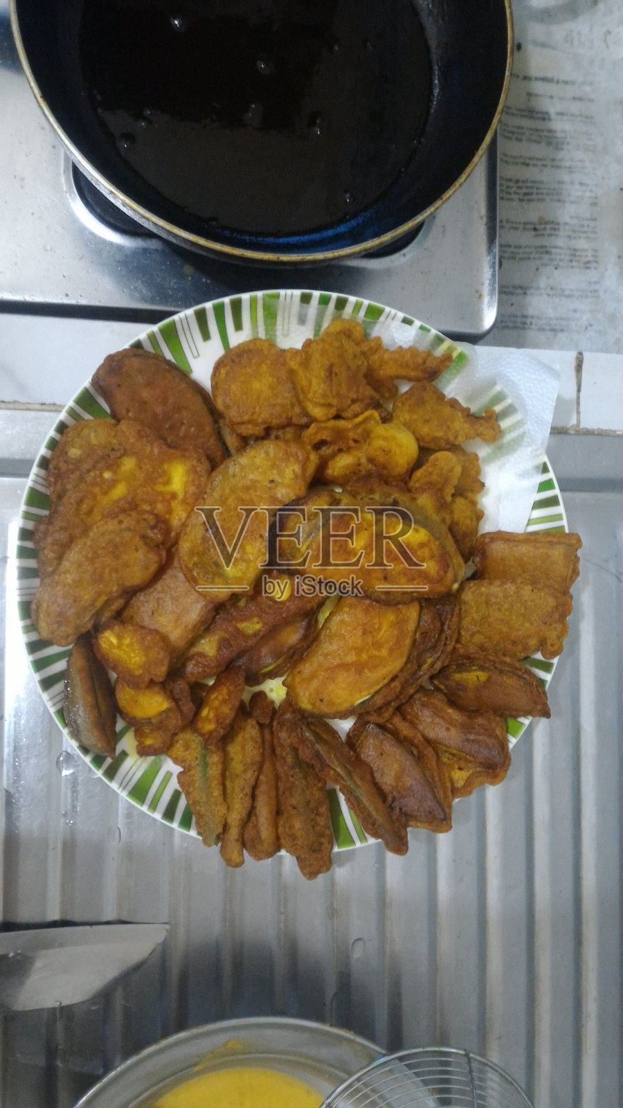 不同种类的油炸蔬菜装饰在一个盘子里。照片摄影图片