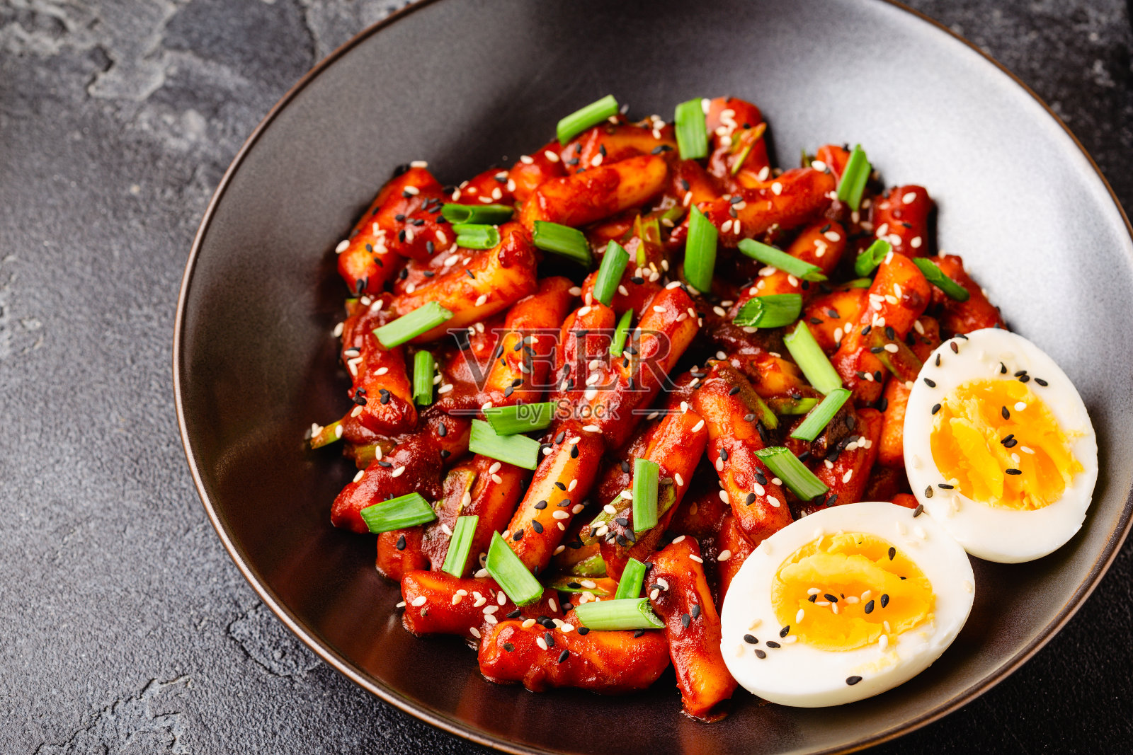 黑碗炒年糕。照片摄影图片