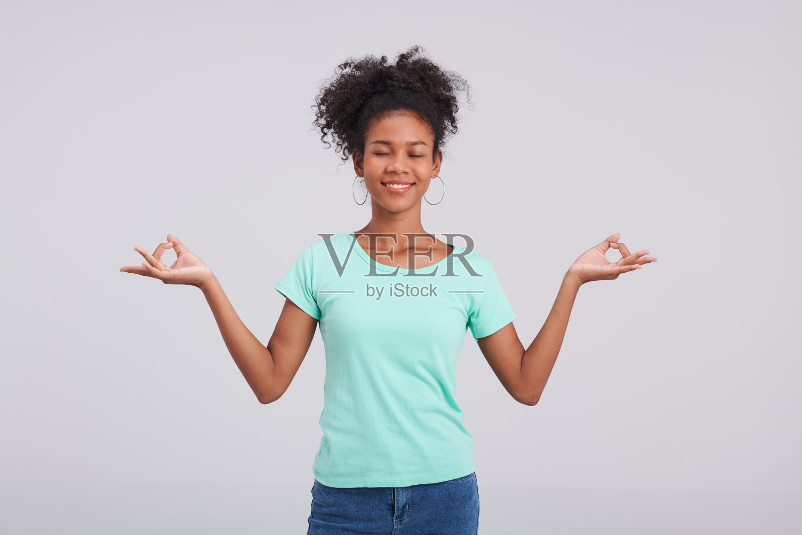 时尚的姿势:女性薄荷衬衫和蓝色牛仔裤工作室的姿势照片摄影图片