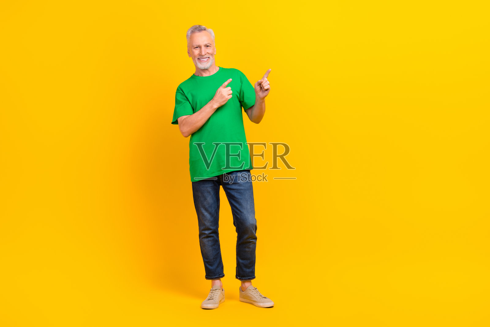 满意的快乐老人的全身肖像直接手指空白的空间提供孤立的黄色背景新闻照片摄影图片