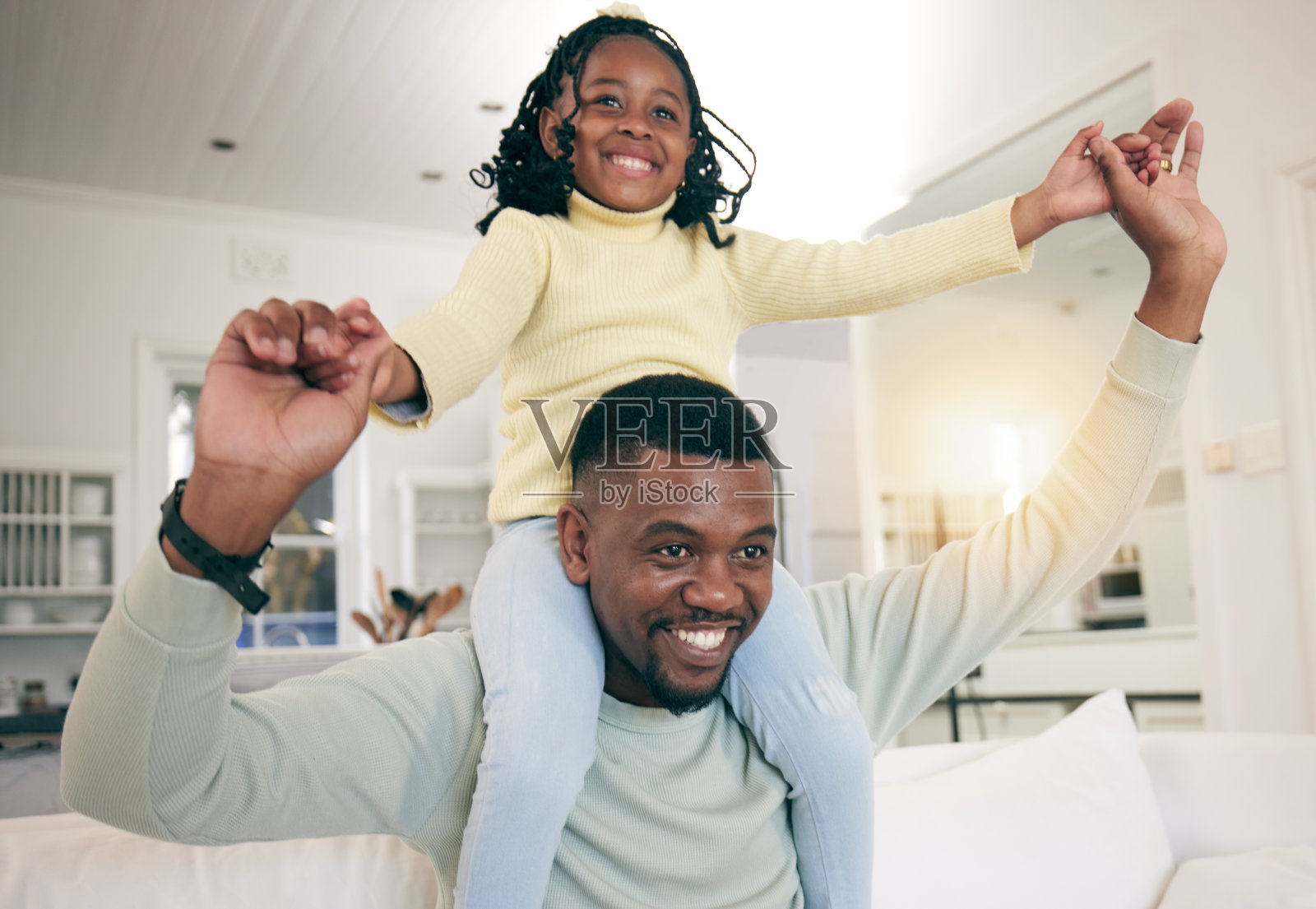 黑人家庭,回家后爸爸和孩子在客厅的沙发上开心地玩耍。父亲的纽带,父母的爱和支持,一个微笑的孩子和父亲在一个有镜头光晕的房子里照片摄影图片