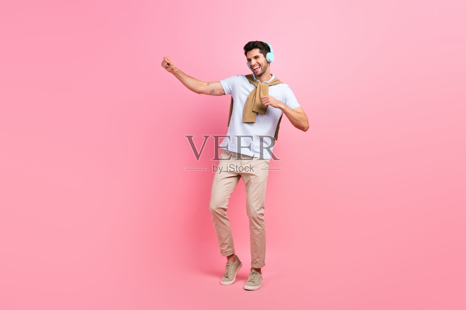 喜出望外的人听着最喜欢的歌曲耳机跳舞孤立的粉红色背景全长照片照片摄影图片