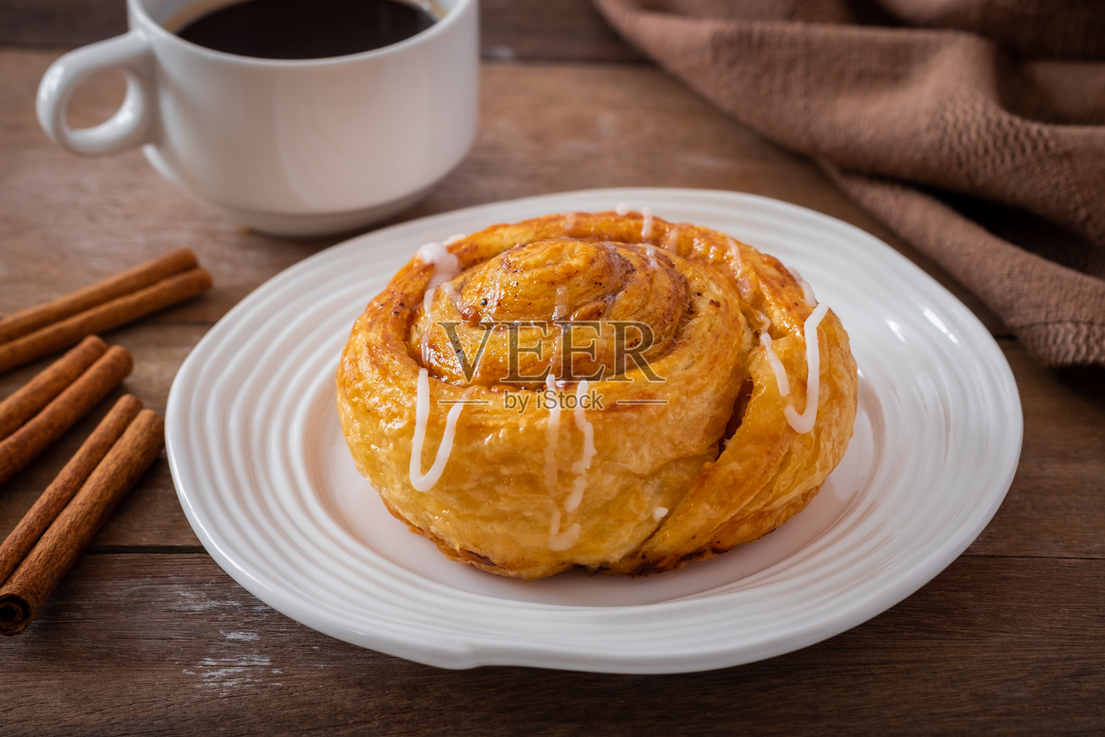 白色盘子里的肉桂卷面包和一杯咖啡照片摄影图片