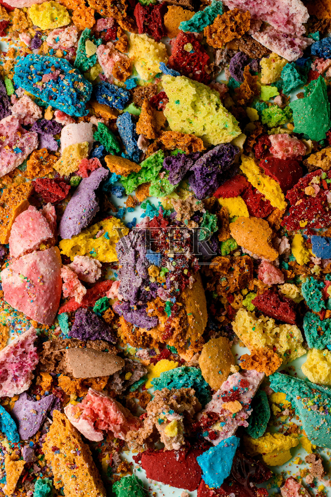 法国甜点马卡龙被压碎和破碎的不同颜色部分的俯视图,凌乱地躺着照片摄影图片