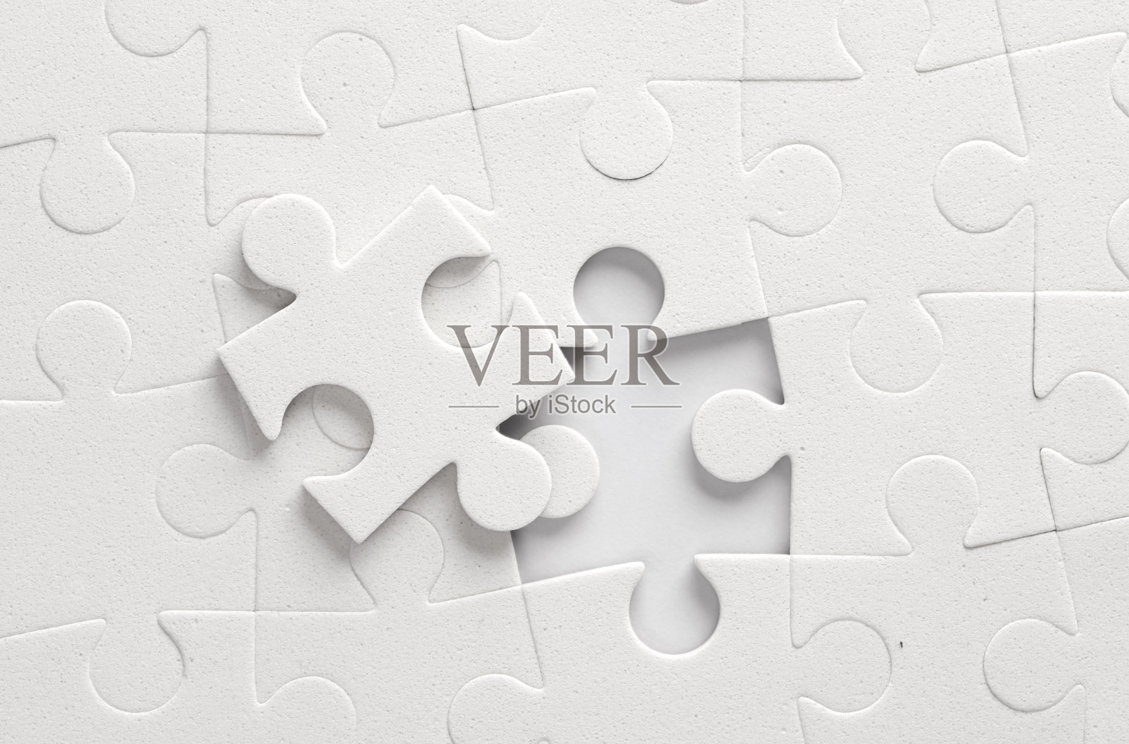 灰色背景上的白色拼图。照片摄影图片