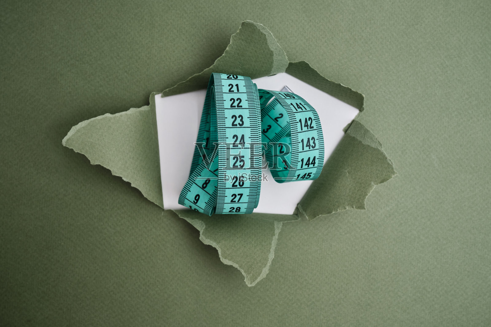 浅色背景上的绿色卷尺。测量长度和体积的工具。用于测量服装行业或人体体积的卷尺照片摄影图片