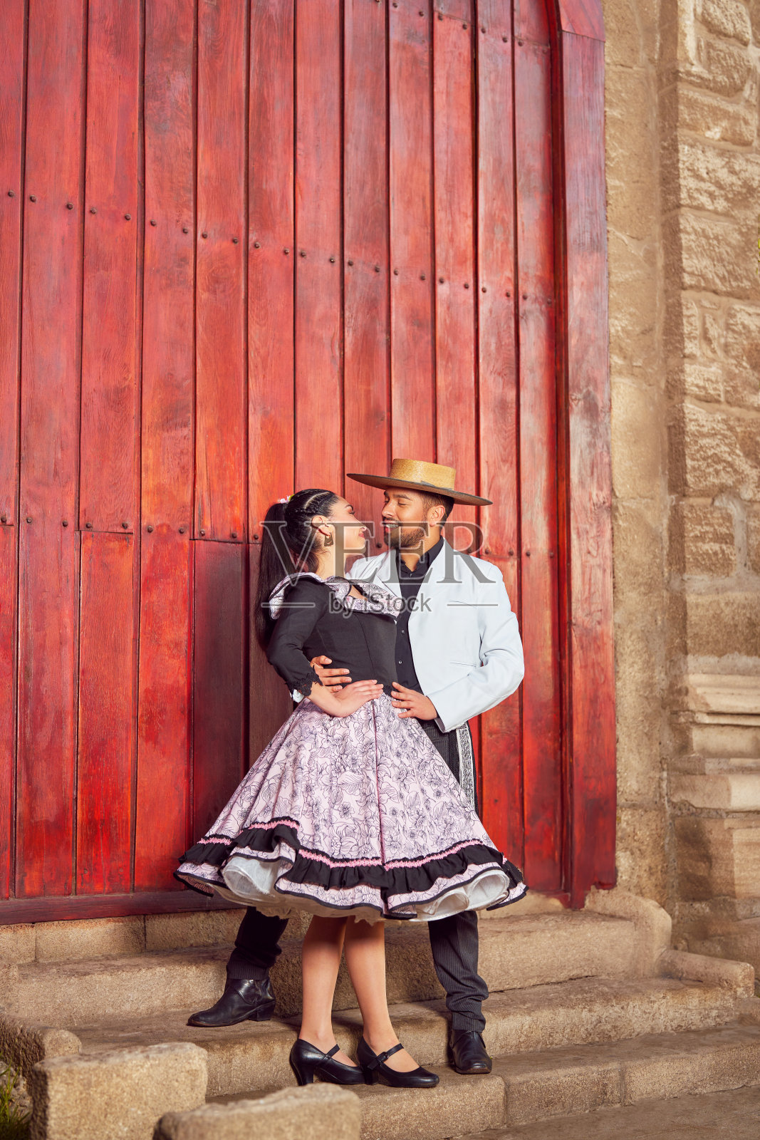 浪漫的肖像,年轻的拉丁美洲夫妇在户外穿着传统的花索服装,面对面地看着对方微笑照片摄影图片