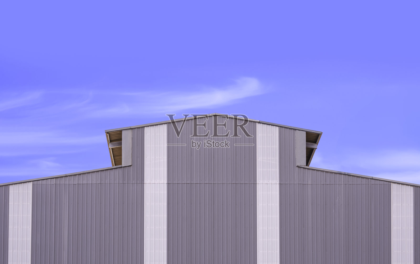 灰色和白色的波纹钢墙与屋顶的大型工业仓库建筑在现代风格的蓝天背景照片摄影图片