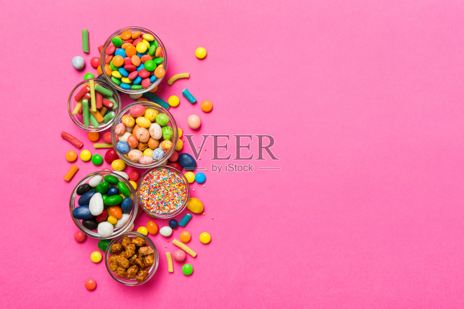 不同颜色的圆形糖果放在碗和罐子里。大品种的糖果和糖果的俯视图与复制空间照片摄影图片