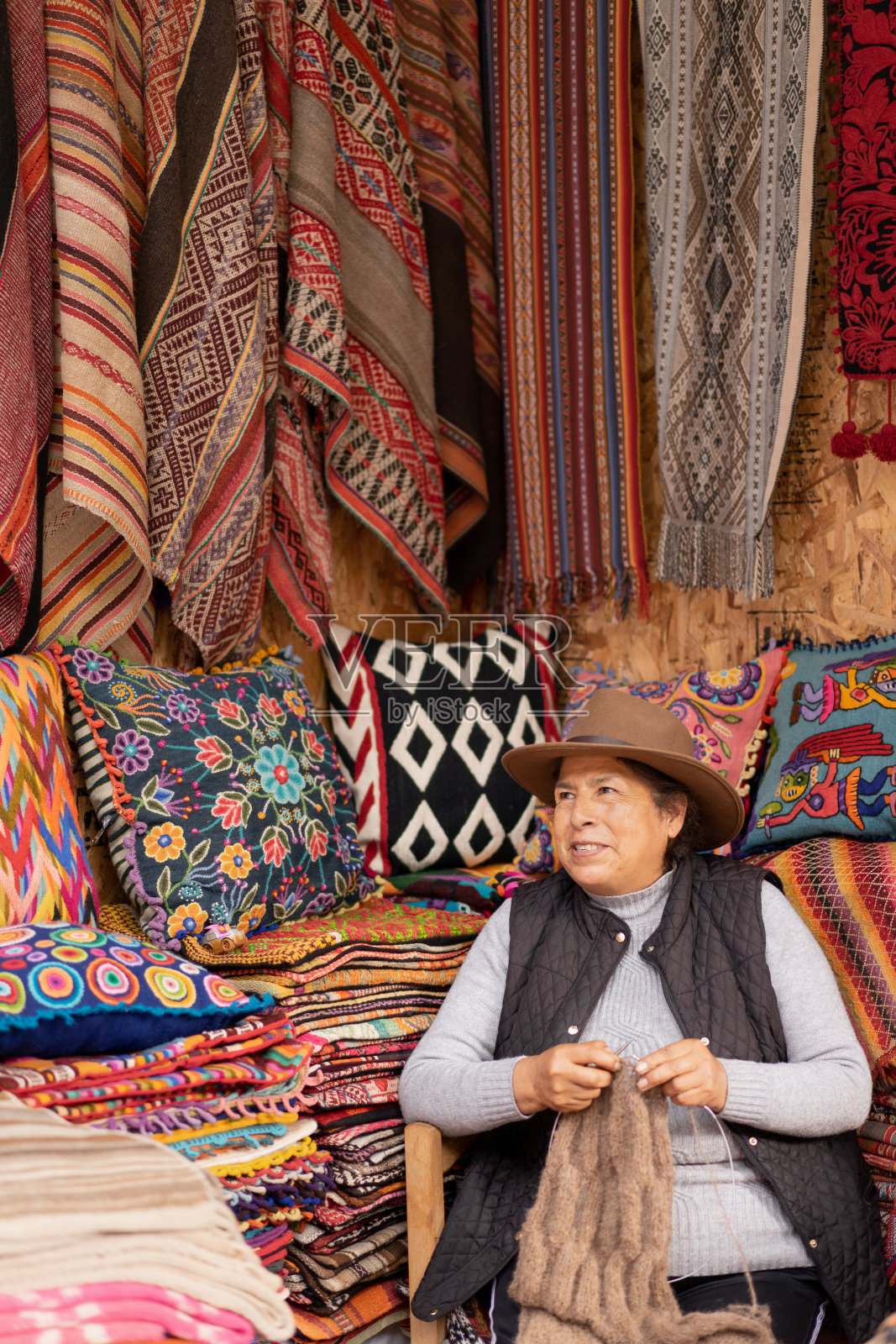一名秘鲁妇女在工艺品店里编织羊驼毛照片摄影图片
