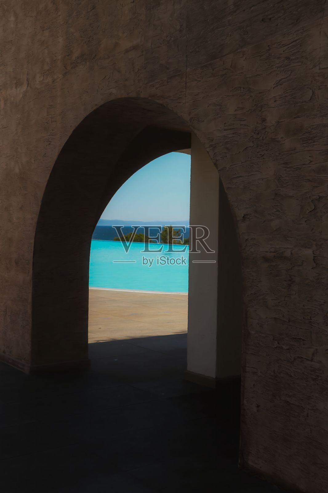 从一个拱形的窗户里俯瞰着一个蓝色的游泳池照片摄影图片