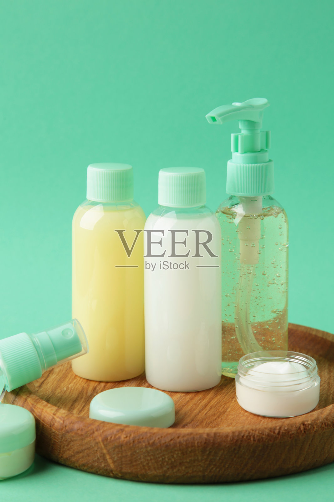 旅行化妆品瓶托盘上薄荷的背景。极简的身体护理美容产品,适合度假或旅行。前视图。Copyspace。照片摄影图片