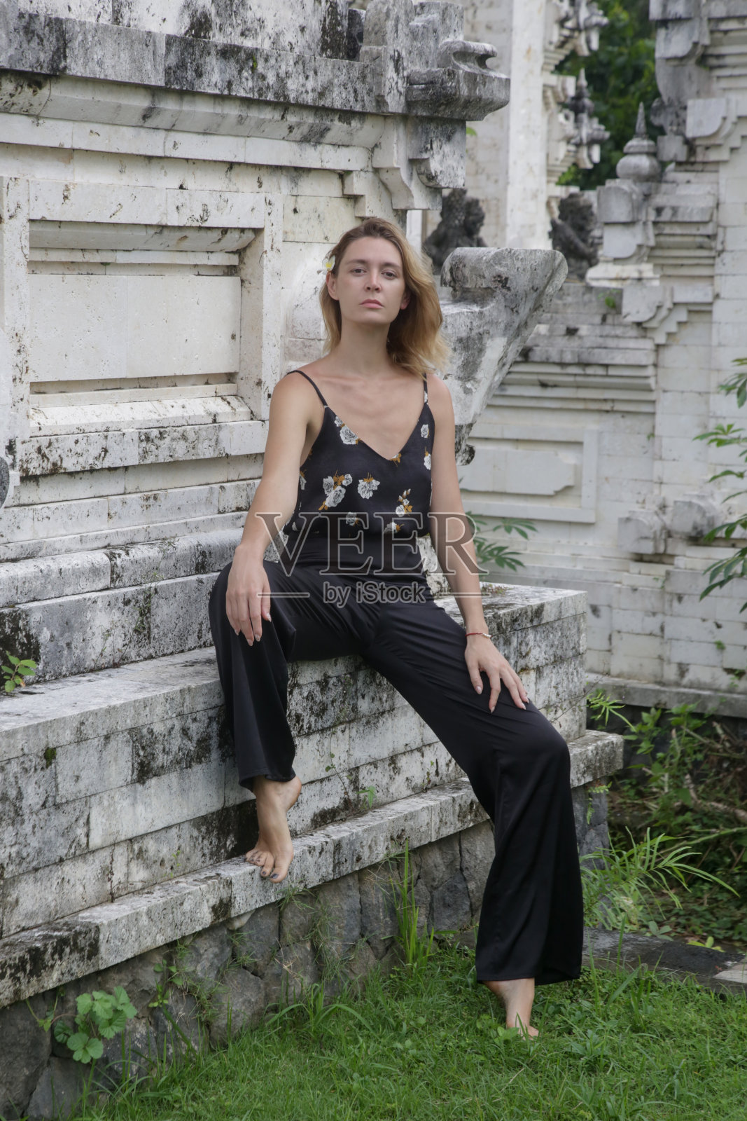 时尚时尚的女游客在白色的巴厘岛寺庙旁摆姿势照片摄影图片