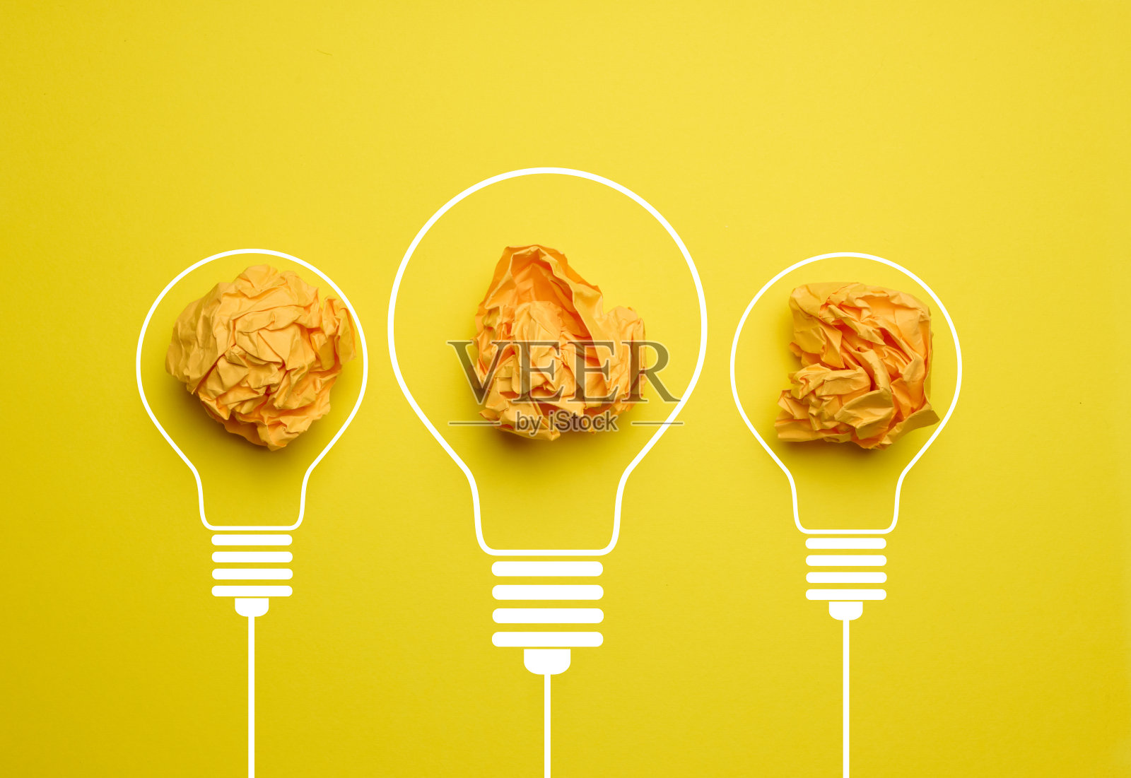 黄色背景的电灯里揉皱的纸团。新想法的概念,头脑风暴照片摄影图片