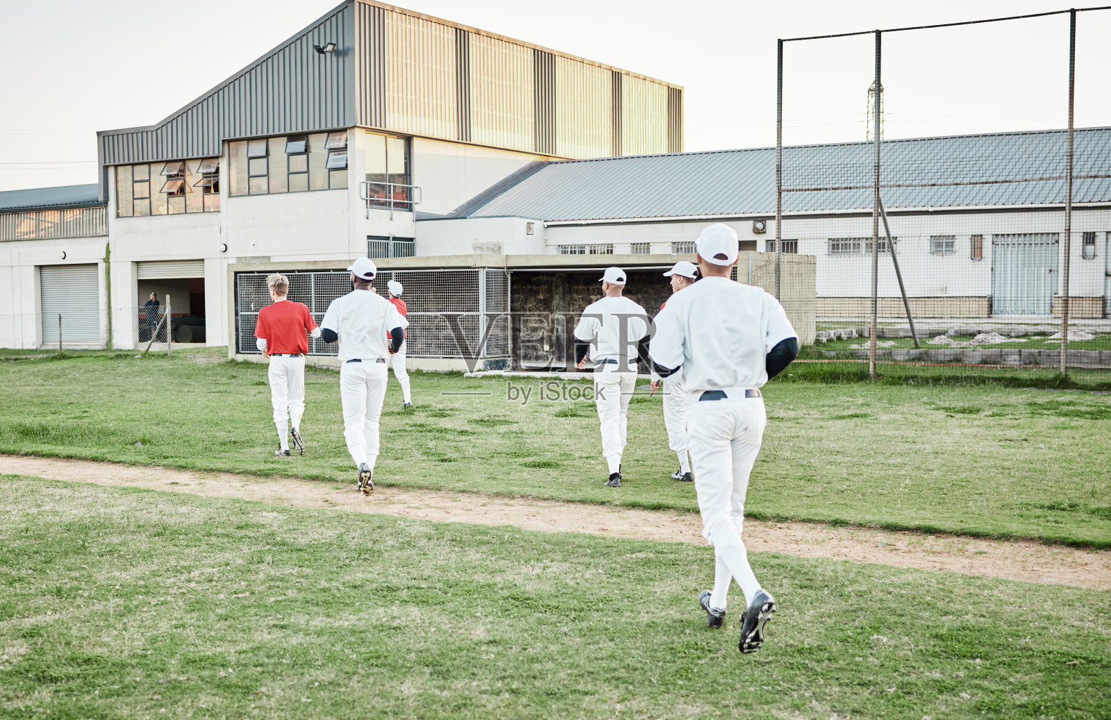体育运动,棒球和为比赛、锻炼或在体育场训练而在场上奔跑的队伍。健身,垒球和一群男运动员为比赛做准备,在球场上锻炼或练习照片摄影图片